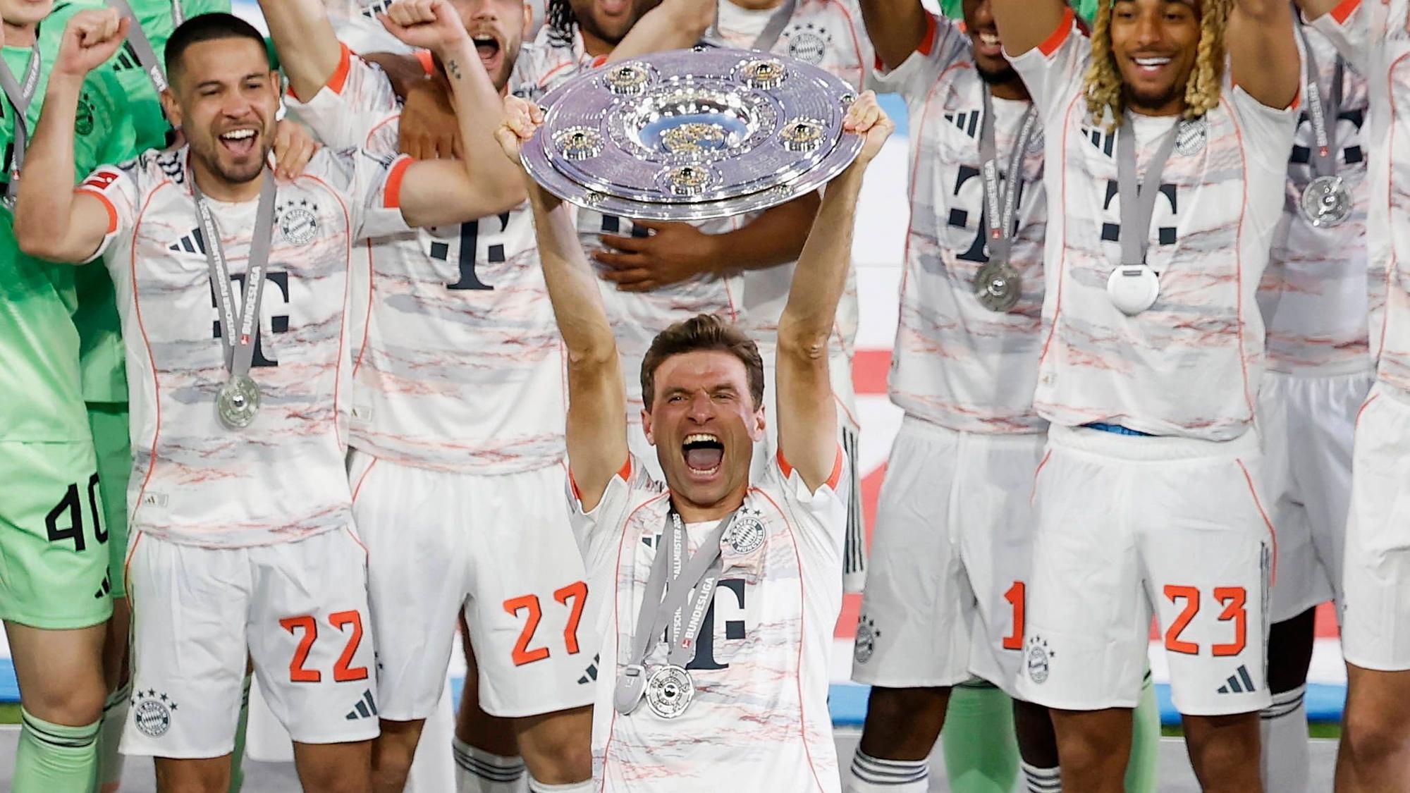 Thomas Müller reckt die Meisterschale in die Höhe.