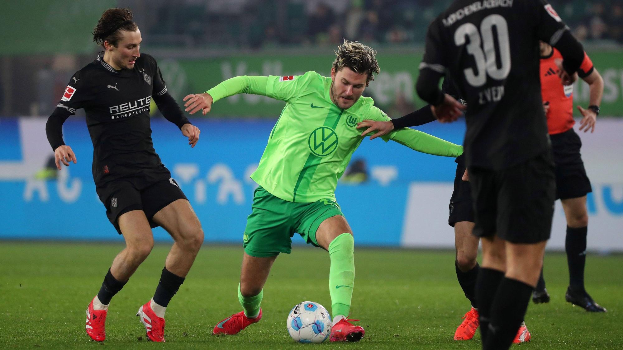 Rocco Reitz von Gladbach im Zweikampf mit Jonas Wind von Wolfsburg.