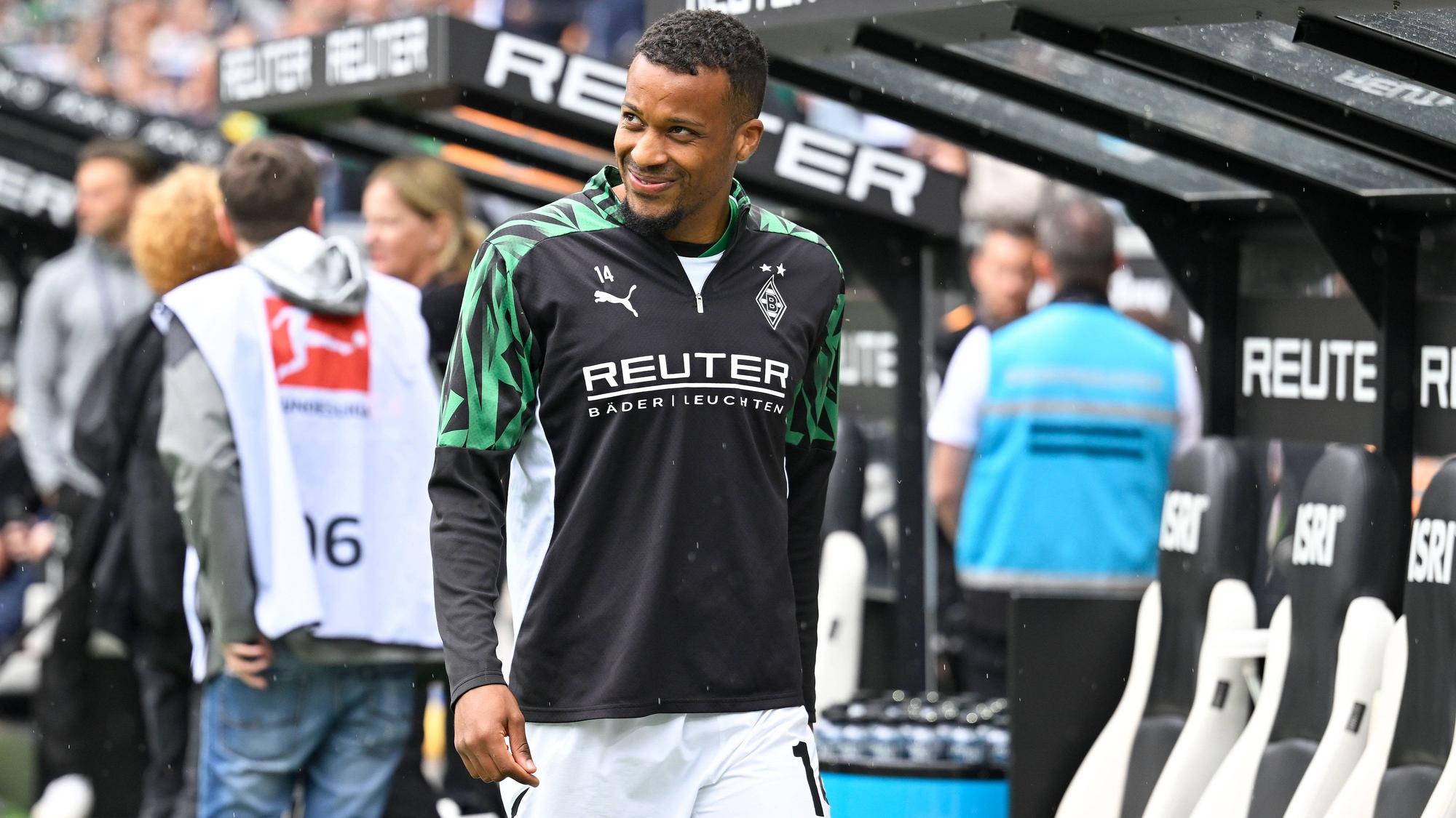 Alassane Plea vor der Borussia-Bank in Trainingsklamotte.