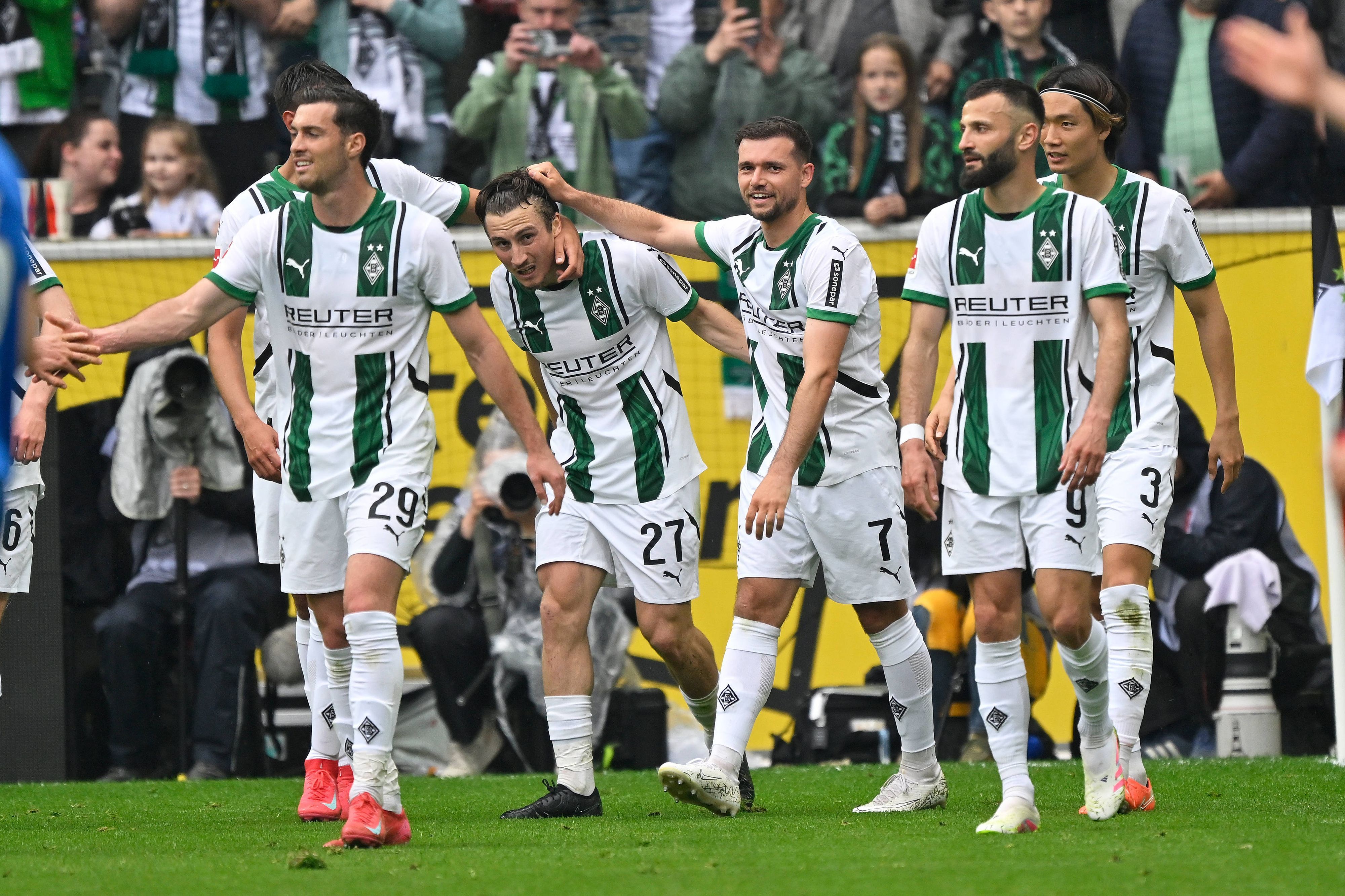 Mehrere Spieler von Borussia Mönchengladbach laufen über den Platz.