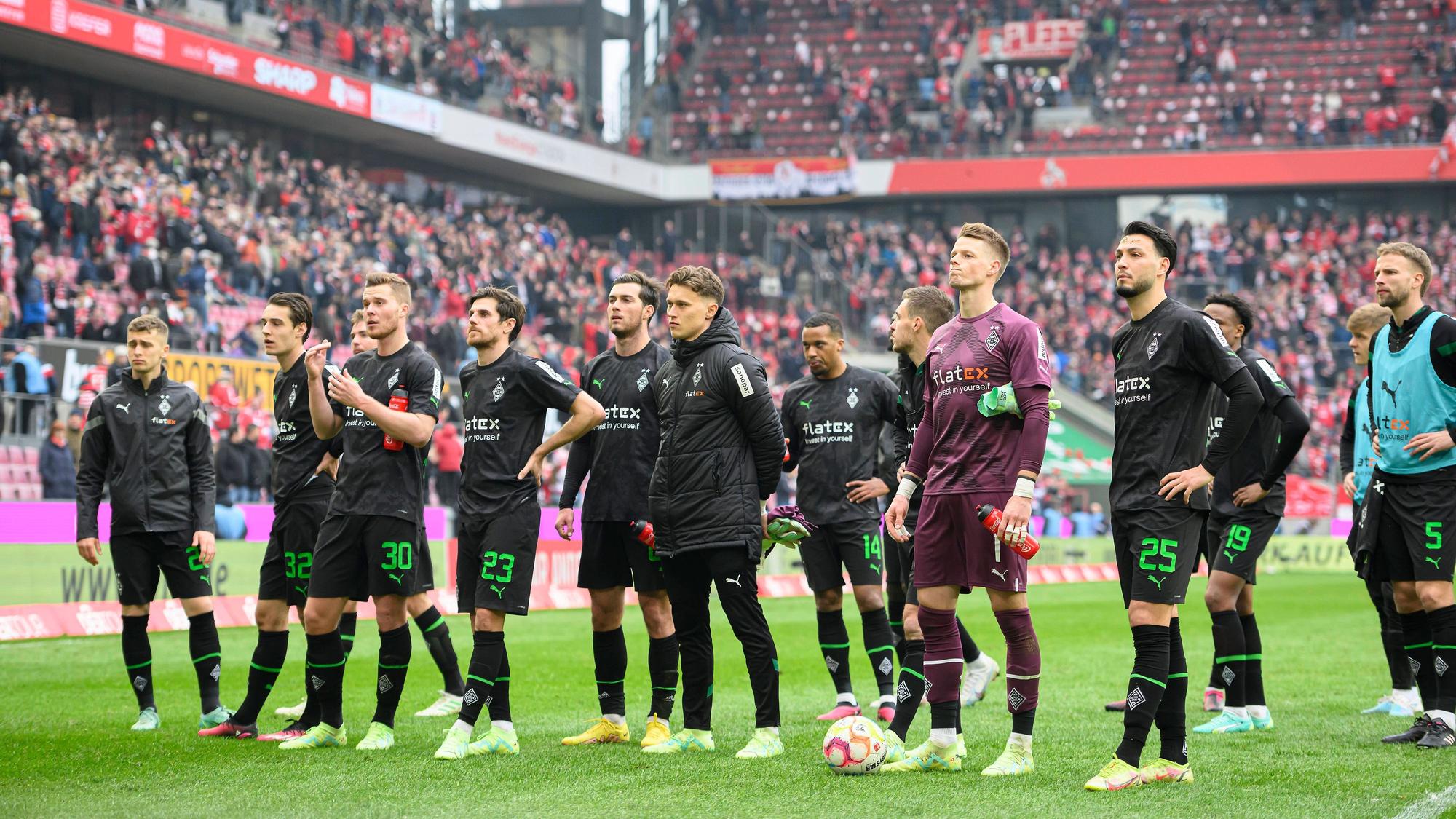 Spieler von Borussia Mönchengladbach vor der Fankurve.