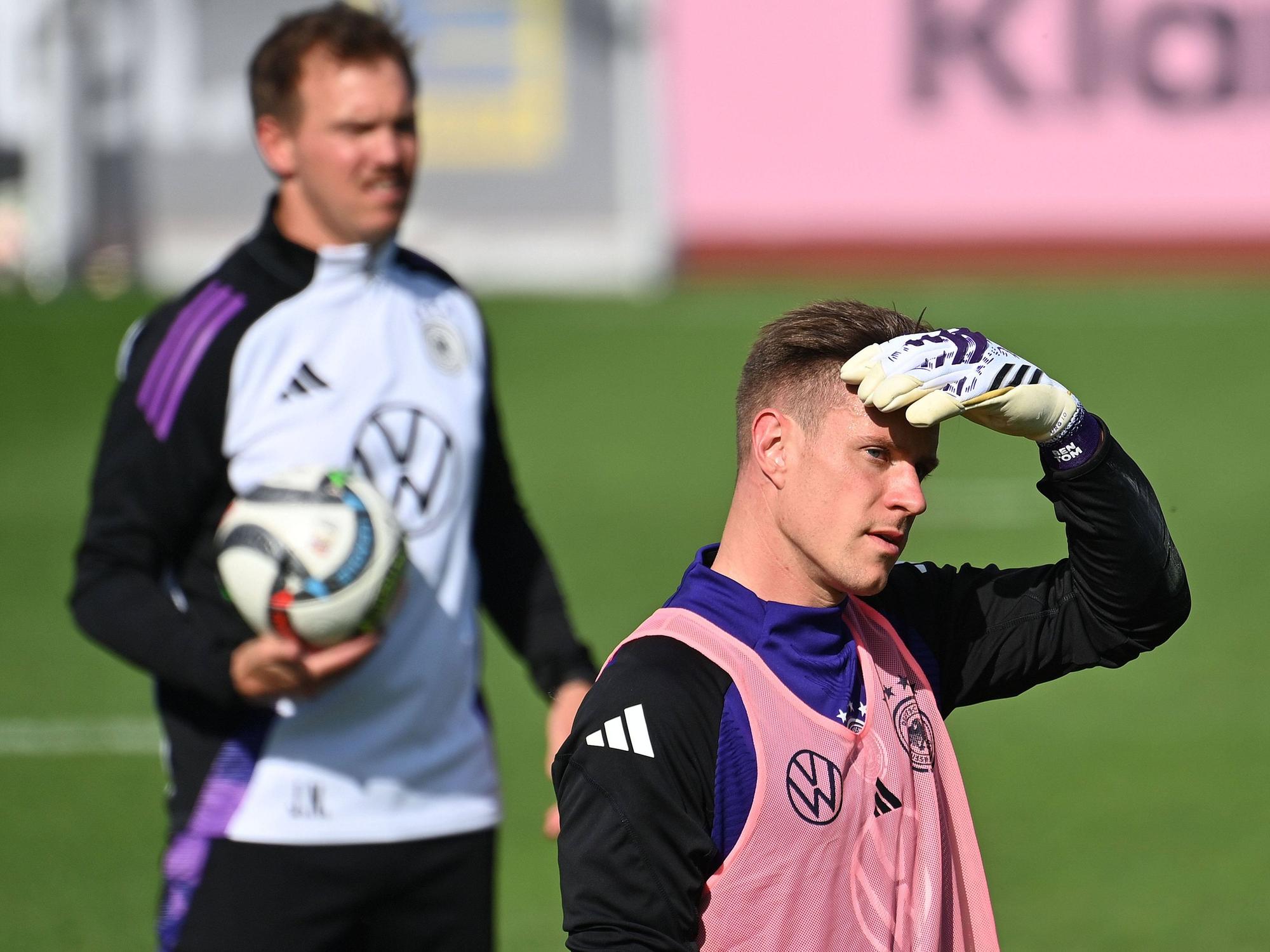 Marc-Andre ter Stegen schützt beim Training seine Augen mit der Hand vor der Sonne, im Hintergrund steht Julian Nagelsmann.
