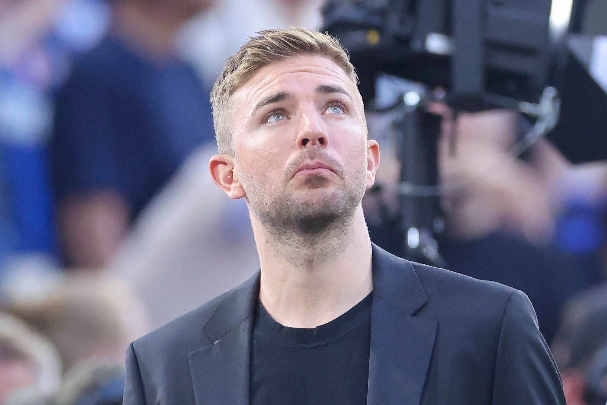 Christoph Kramer schaut im Anzug in den Abendhimmel.
