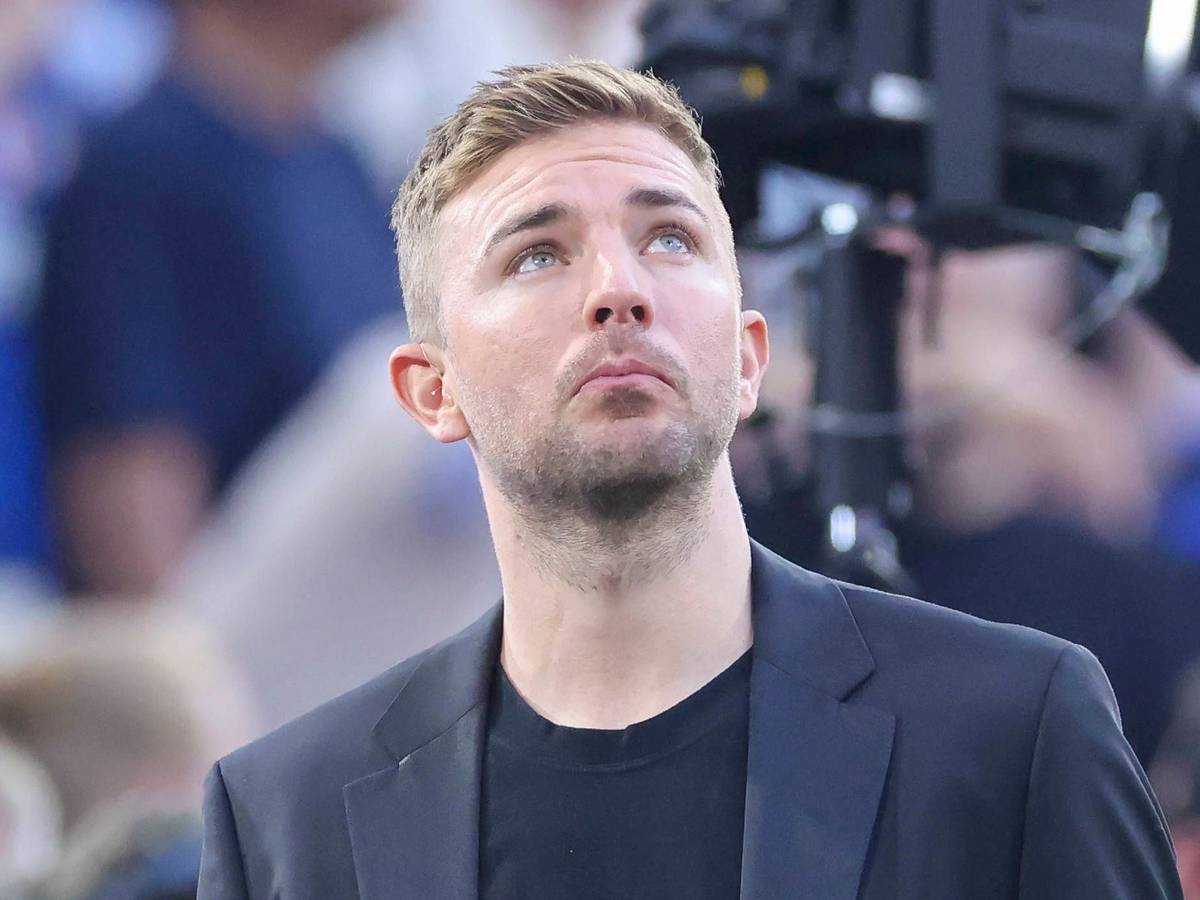 Christoph Kramer schaut im Anzug in den Abendhimmel.