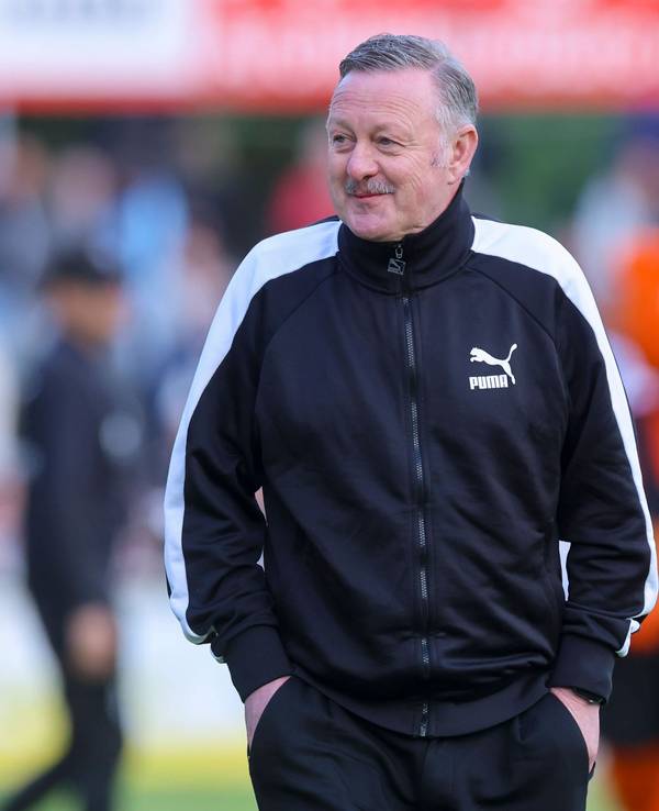 Roland Virkus grinst am Spielfeldrand.