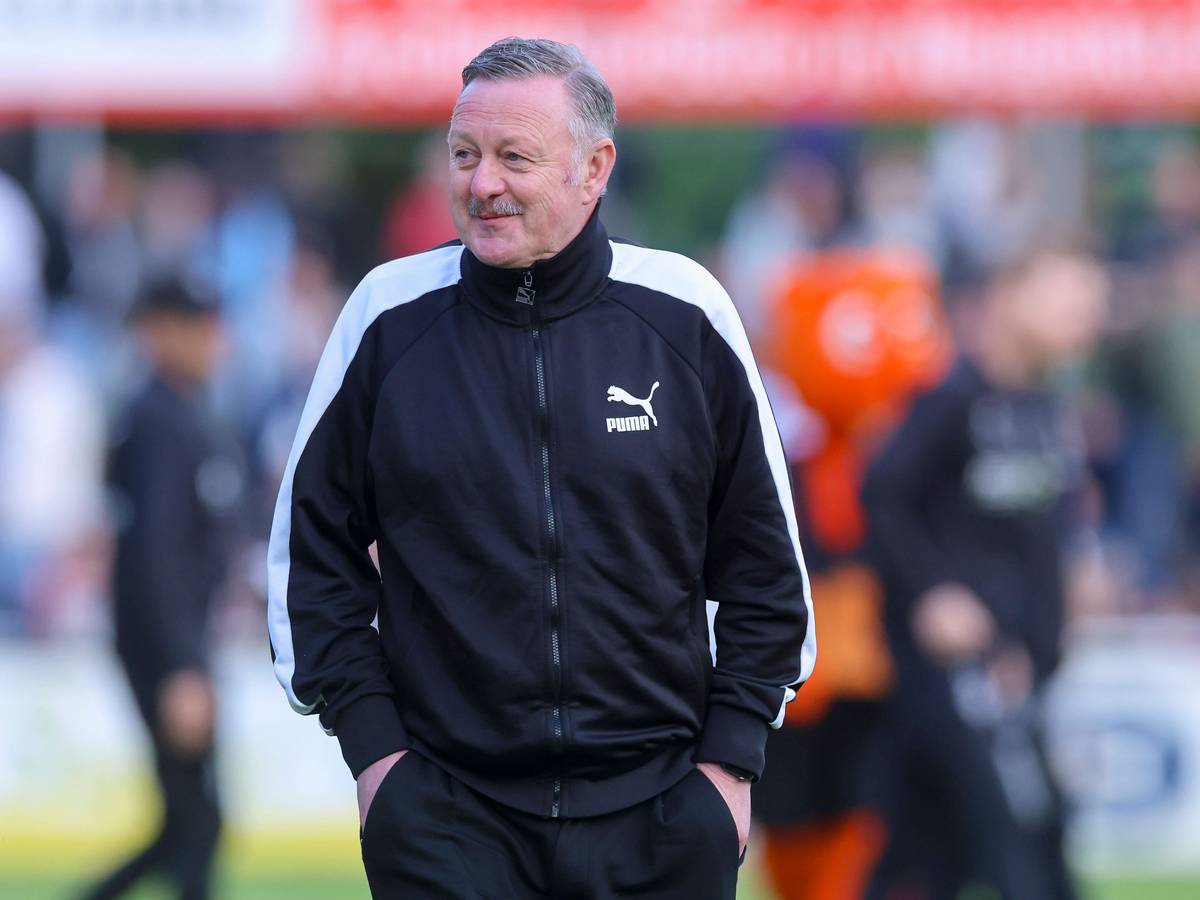 Roland Virkus grinst am Spielfeldrand.