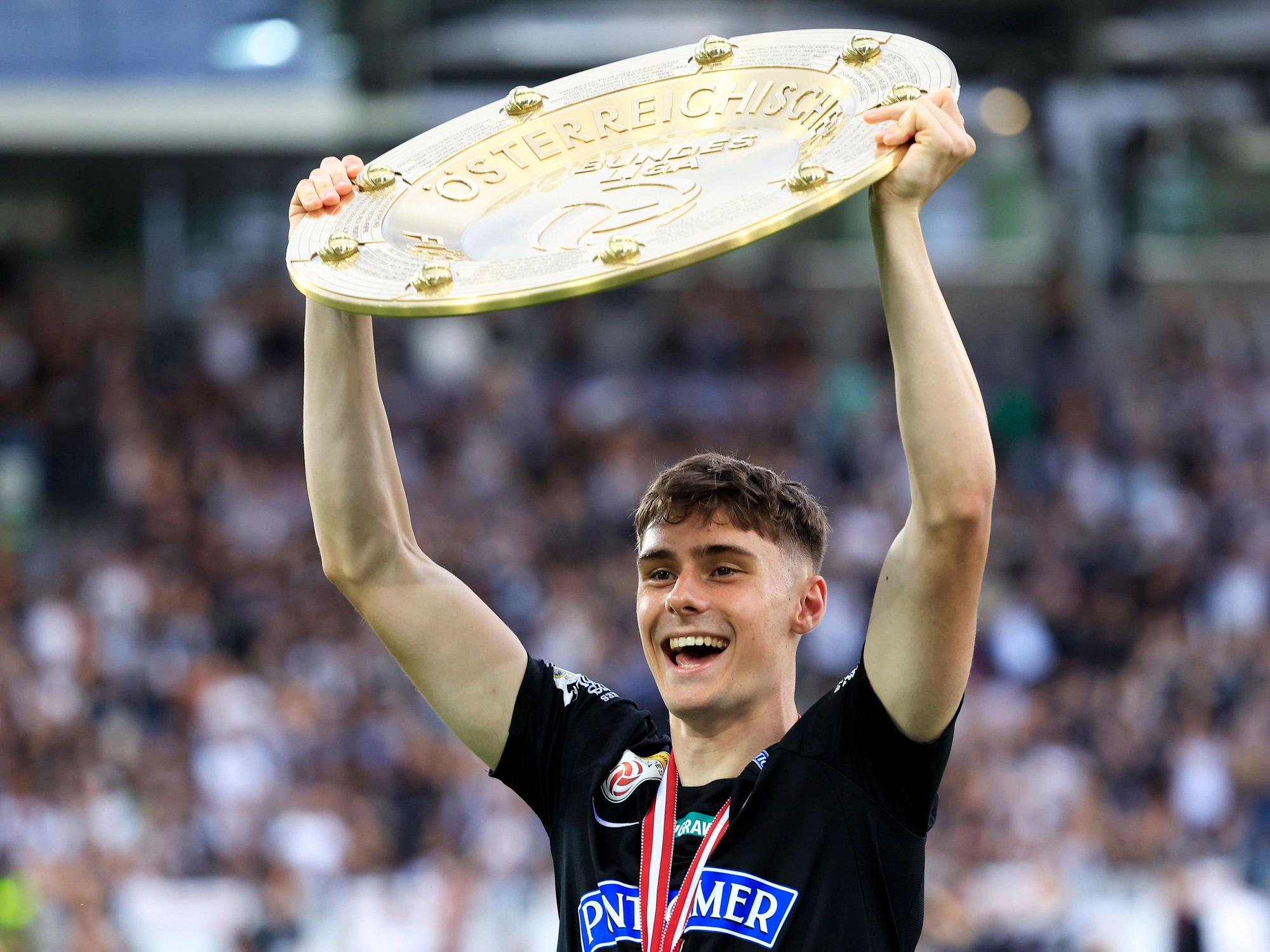 Szymon Wlodarczyk hält die Meisterschale nach oben.