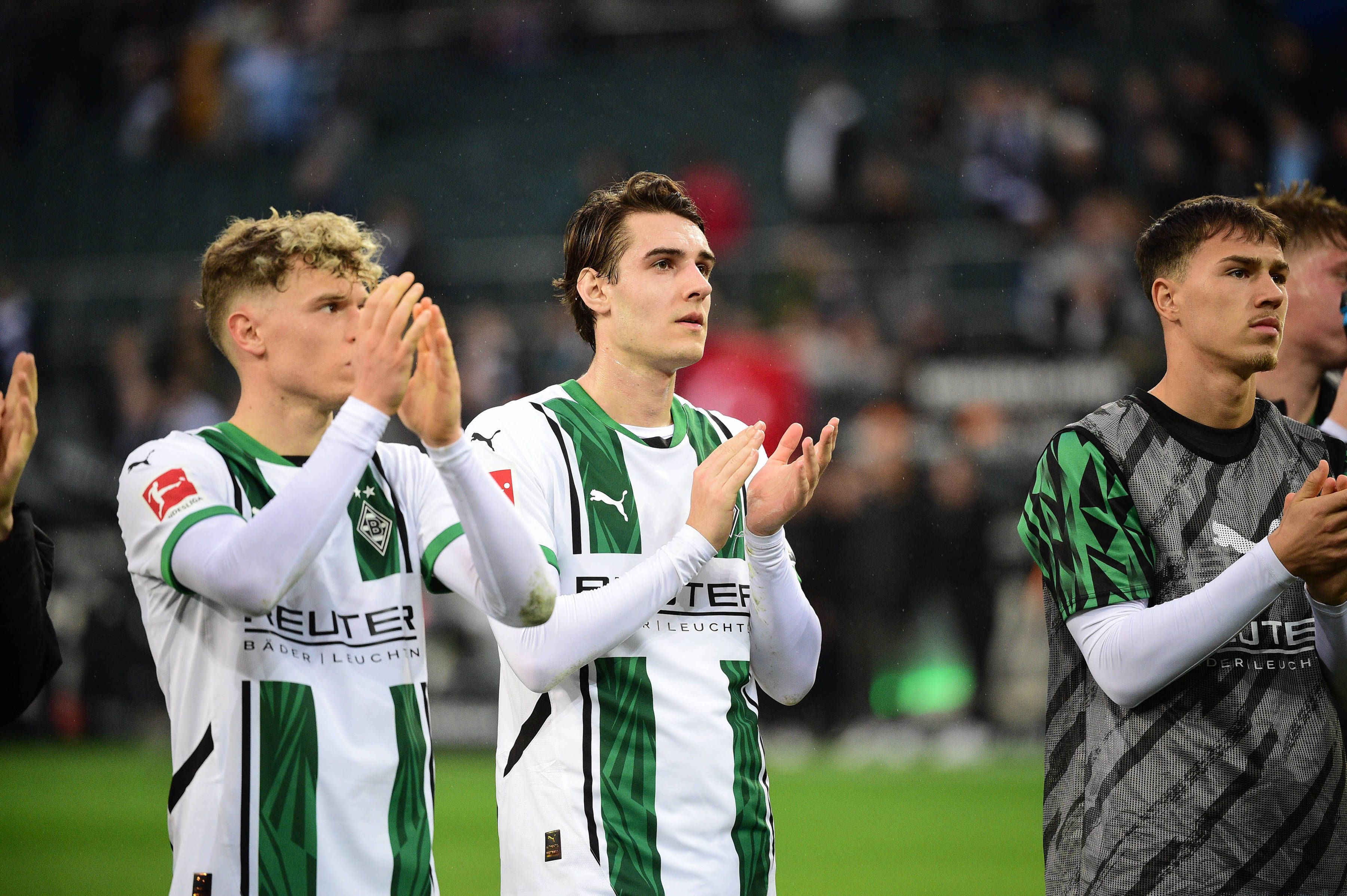Robin Hack, Flo Neuhaus und Noah Pesch applaudieren den Fans.