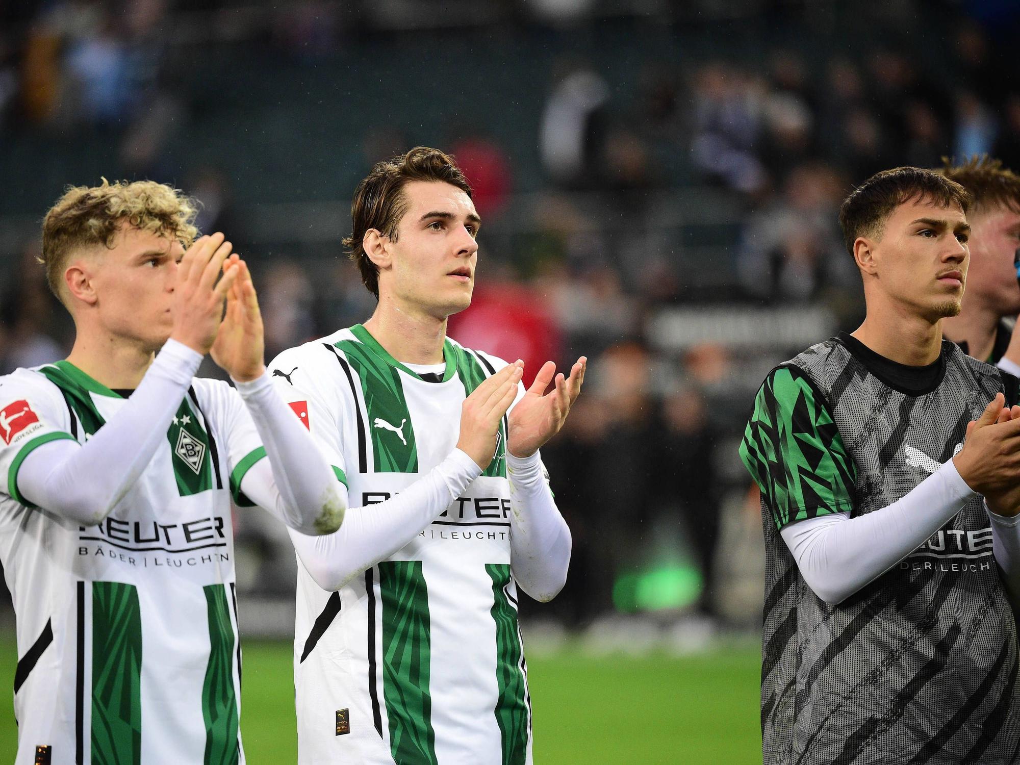Robin Hack, Flo Neuhaus und Noah Pesch applaudieren den Fans.