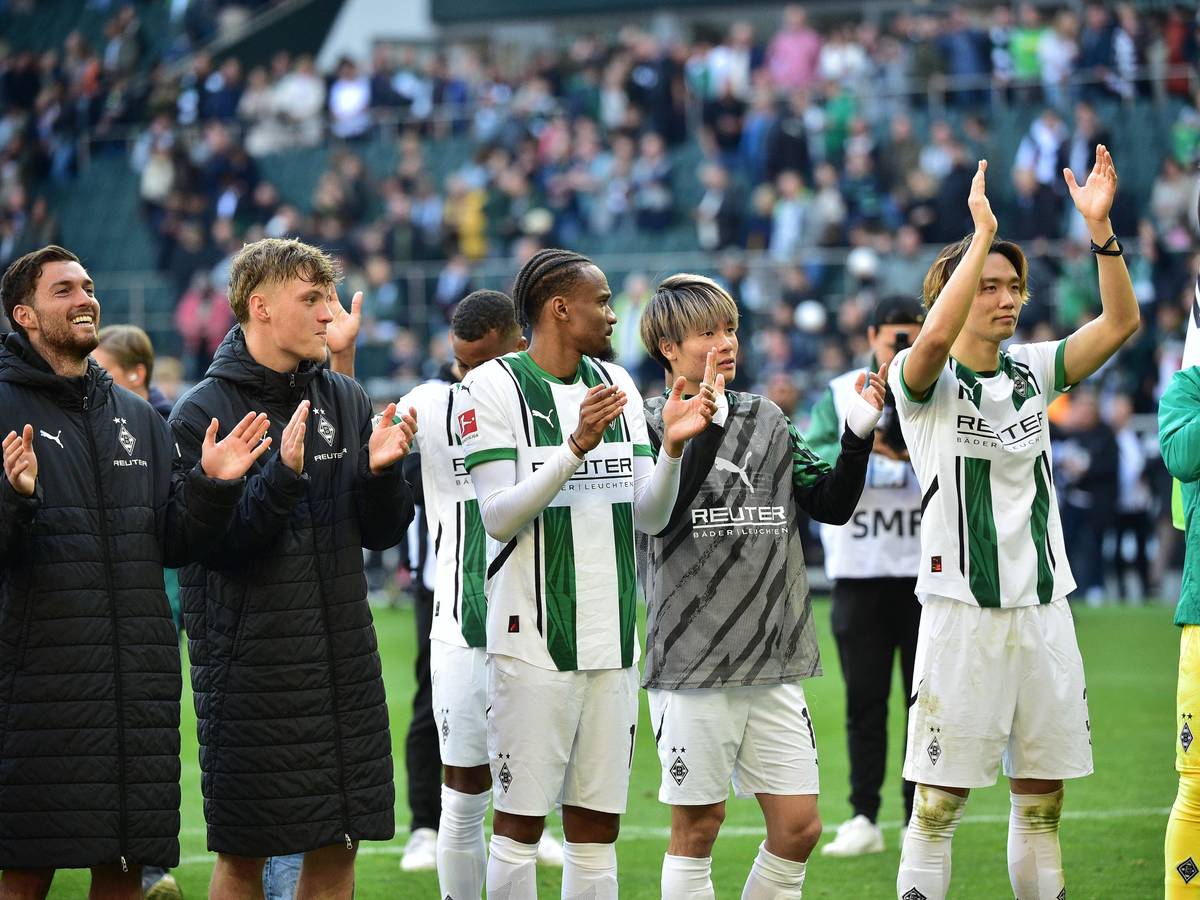 Spieler von Borussia Mönchengladbach feiern mit den Fans vor der Nordkurve.