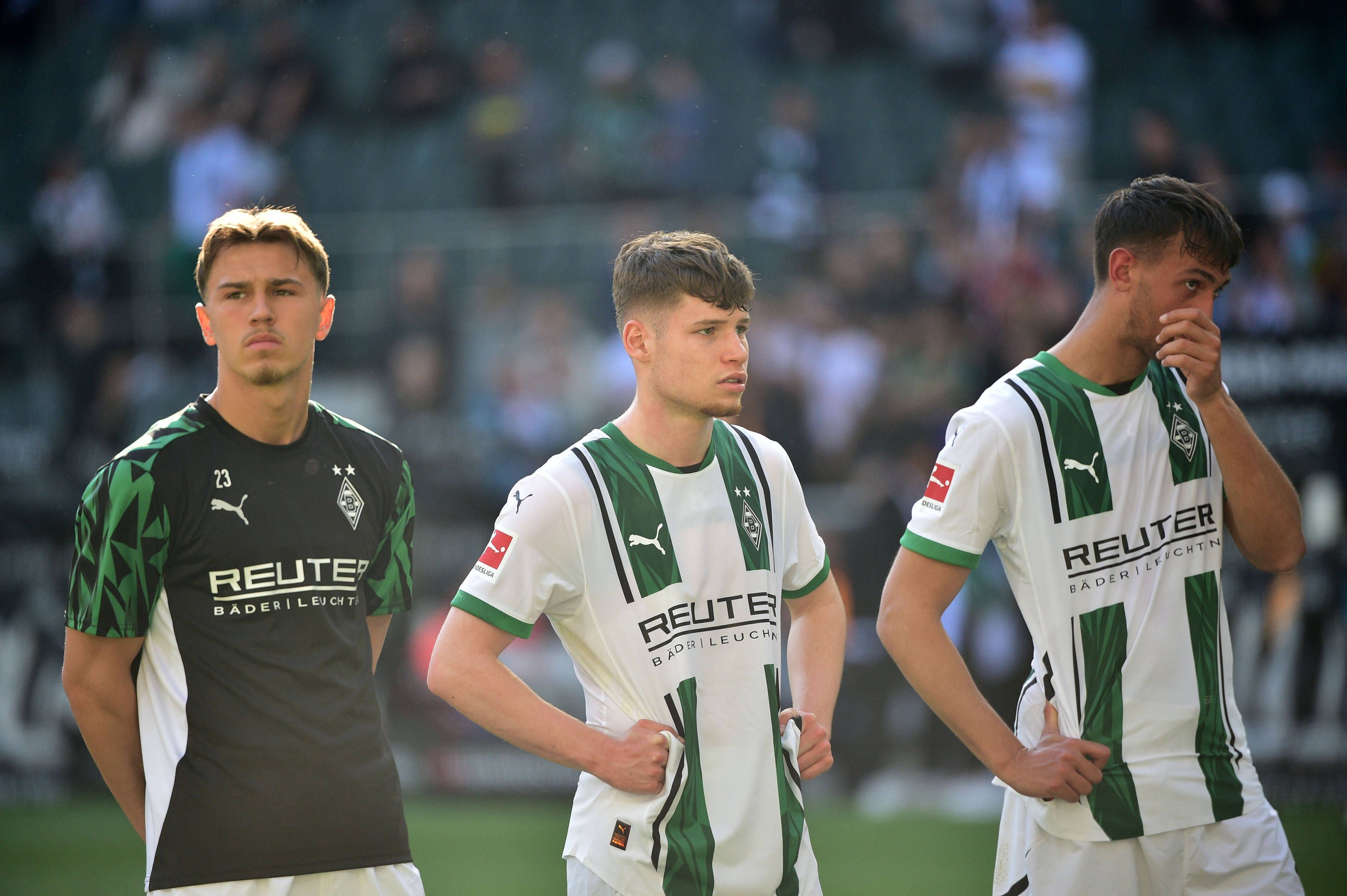 Noah Pesch steht neben Lukas Ullrich und Fabio Chiarodia vor der Fankurve.