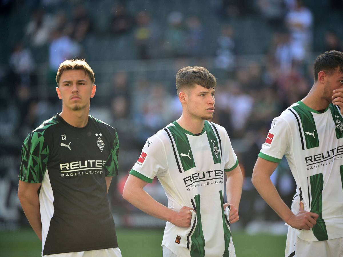 Noah Pesch steht neben Lukas Ullrich und Fabio Chiarodia vor der Fankurve.