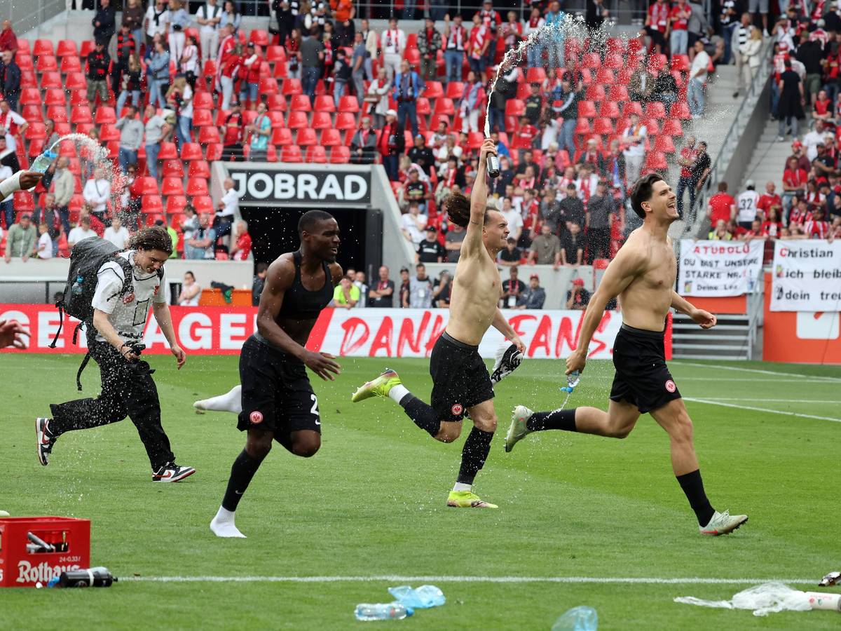 Frankfurt-Spieler jubeln oberkörperfrei vor dem Gästeblock in Freiburg.