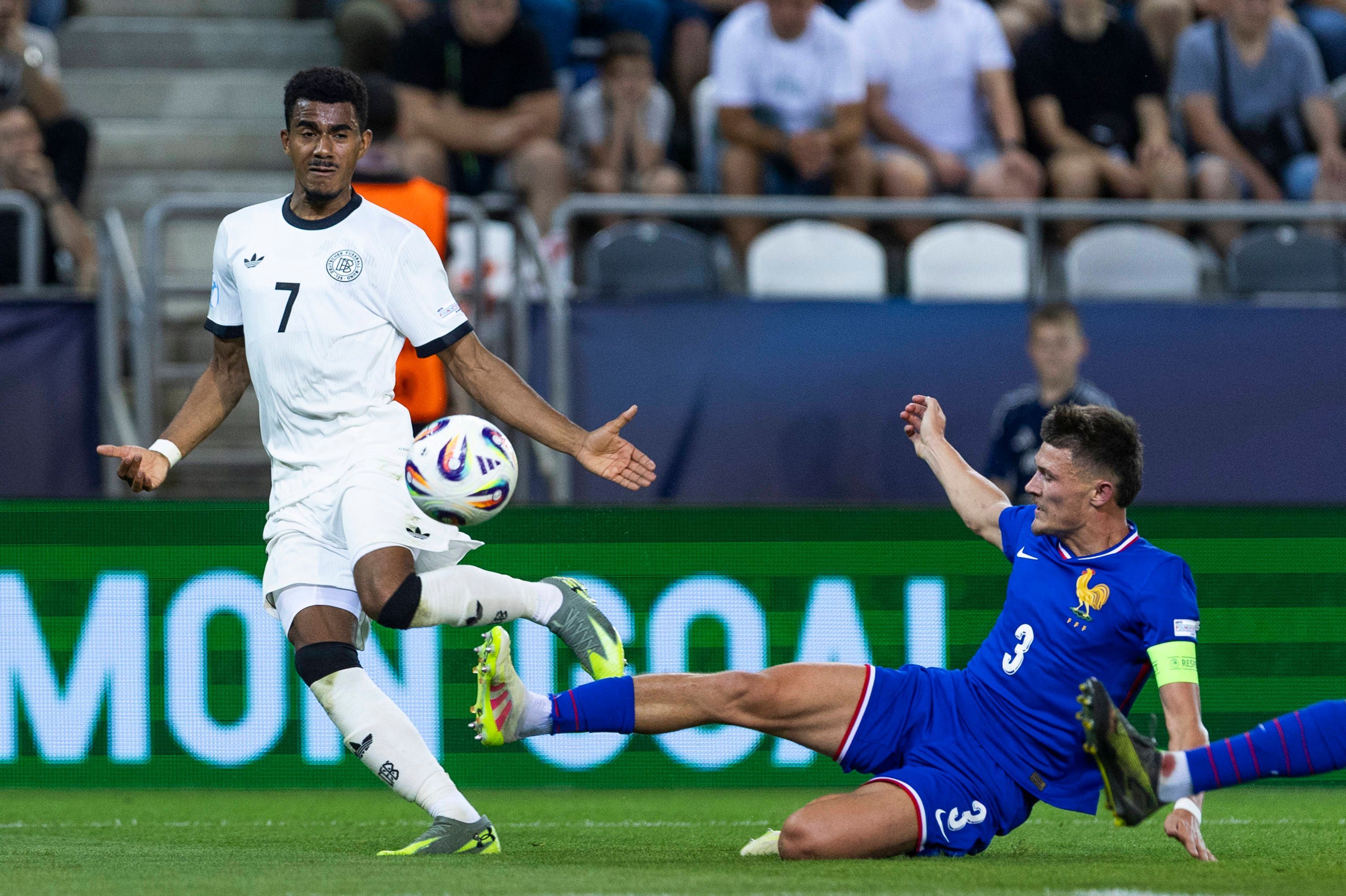 Quentin Merlin grätscht für Frankreich gegen Deutschland. Er trägt die Kapitänsbinde.