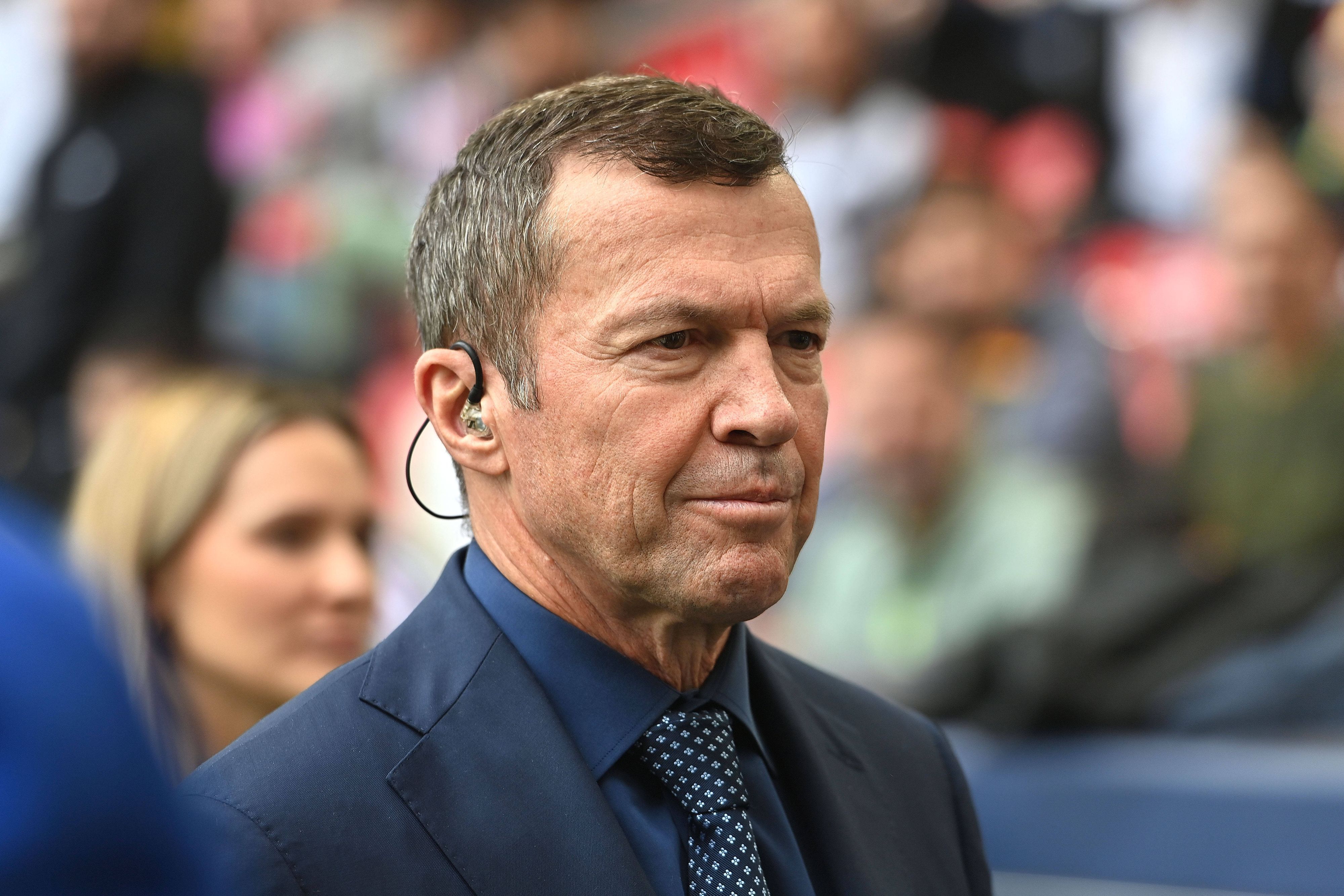 Lothar Matthäus im Anzug an der Seitenlinie.