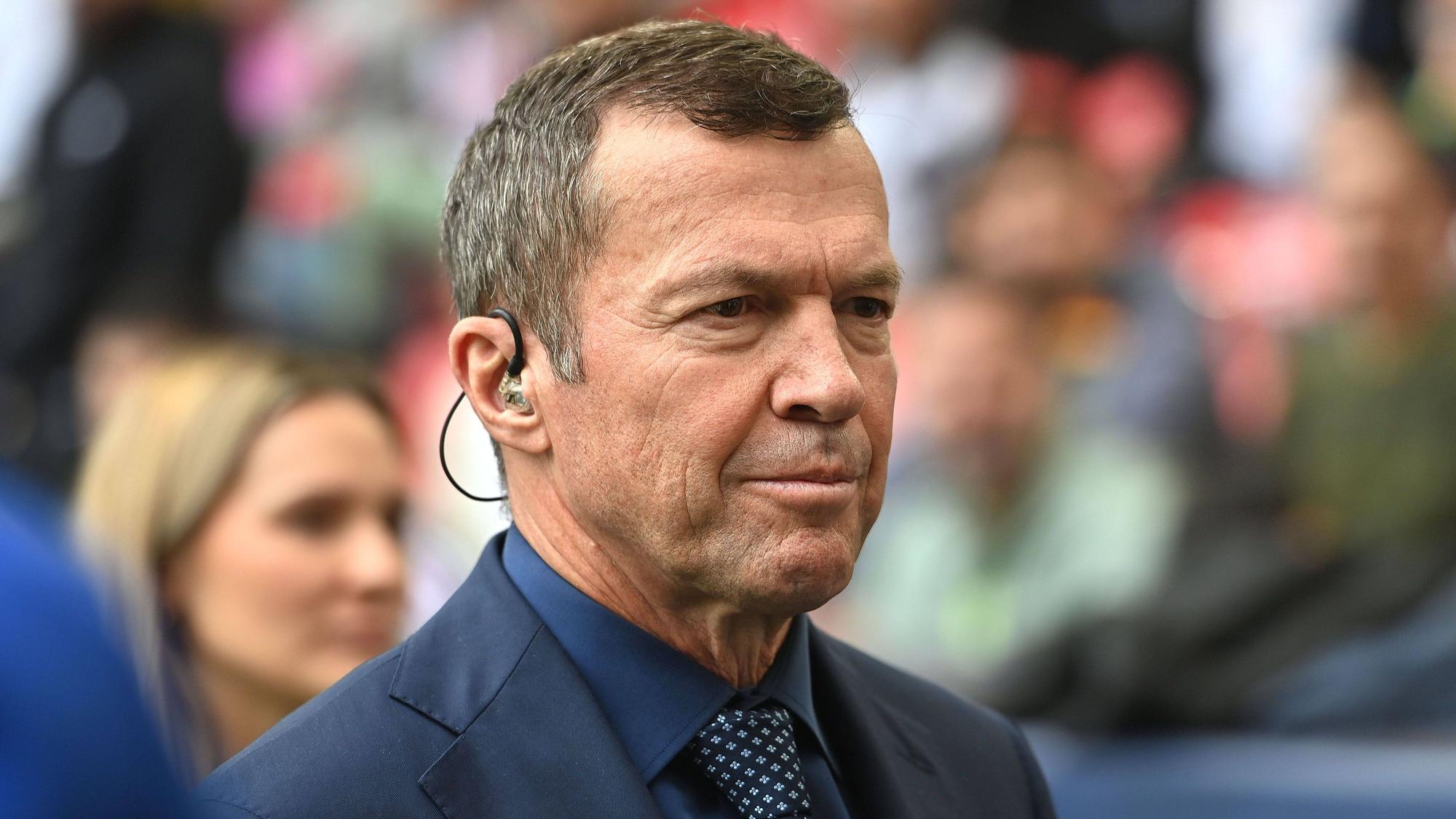 Lothar Matthäus im Anzug an der Seitenlinie.