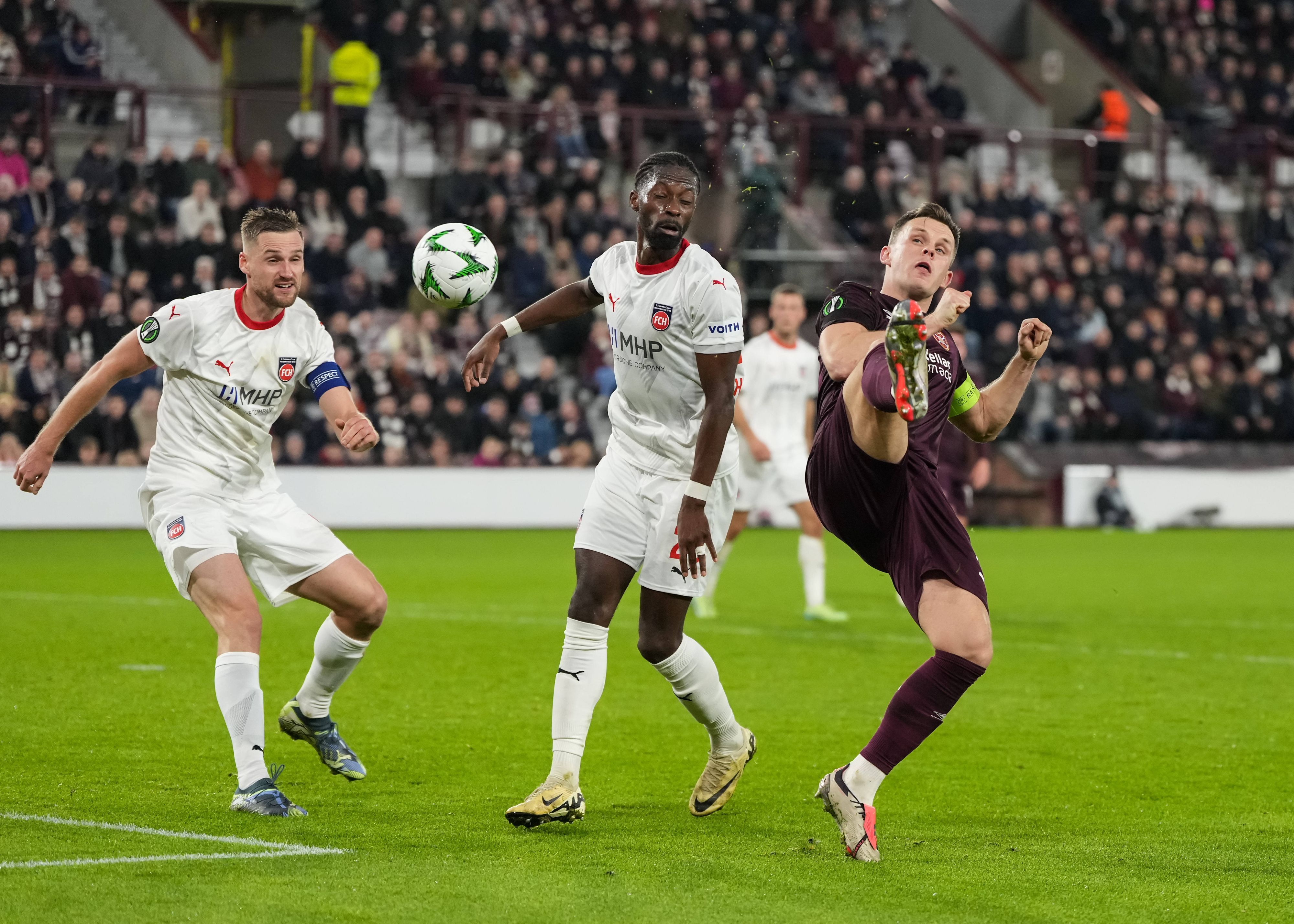 Omar Traoré schaut darauf, wie Lawrence Shankland verzweifelt versucht, den Ball unter Kontrolle zu bringen.