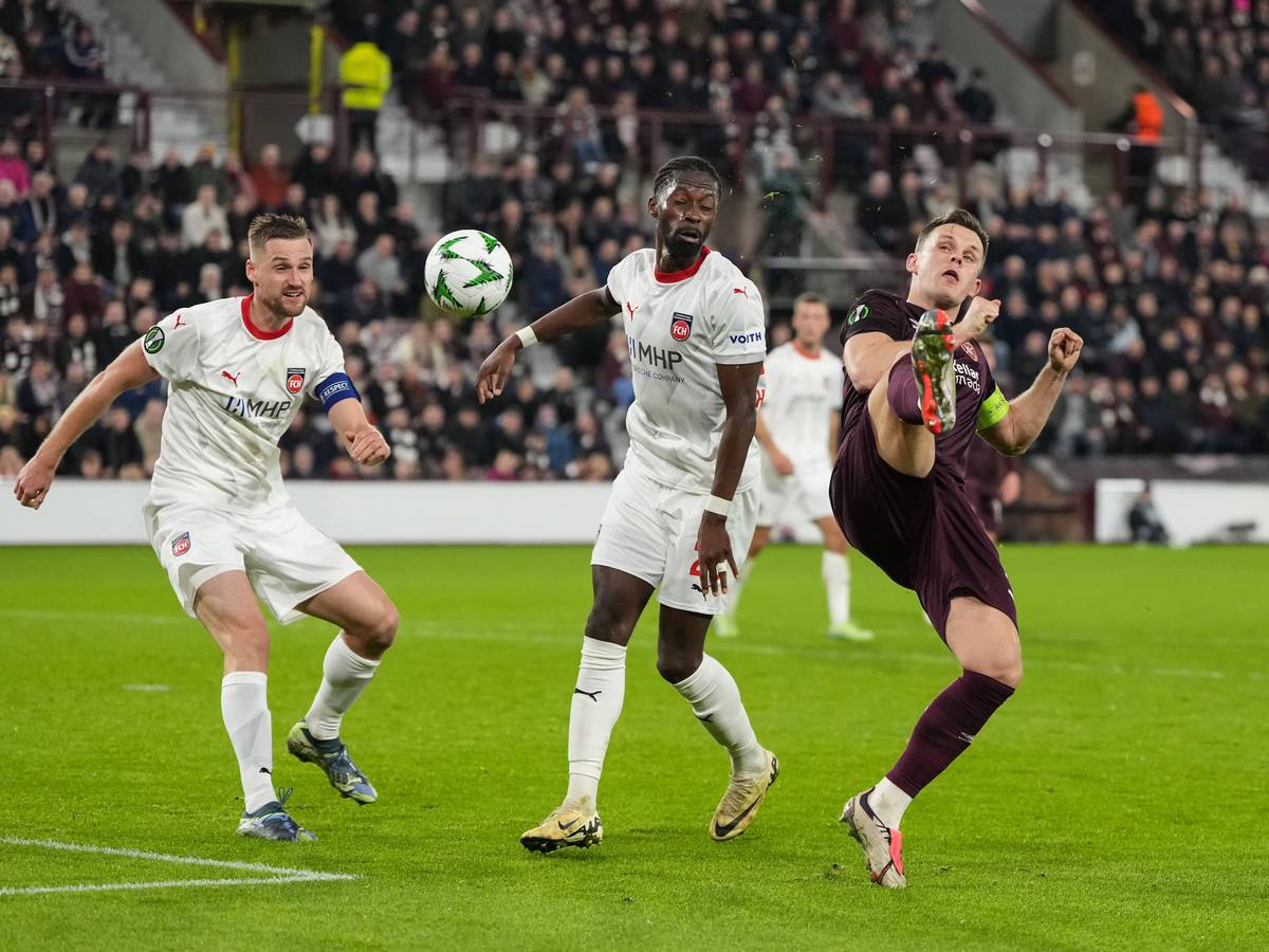 Omar Traoré schaut darauf, wie Lawrence Shankland verzweifelt versucht, den Ball unter Kontrolle zu bringen.
