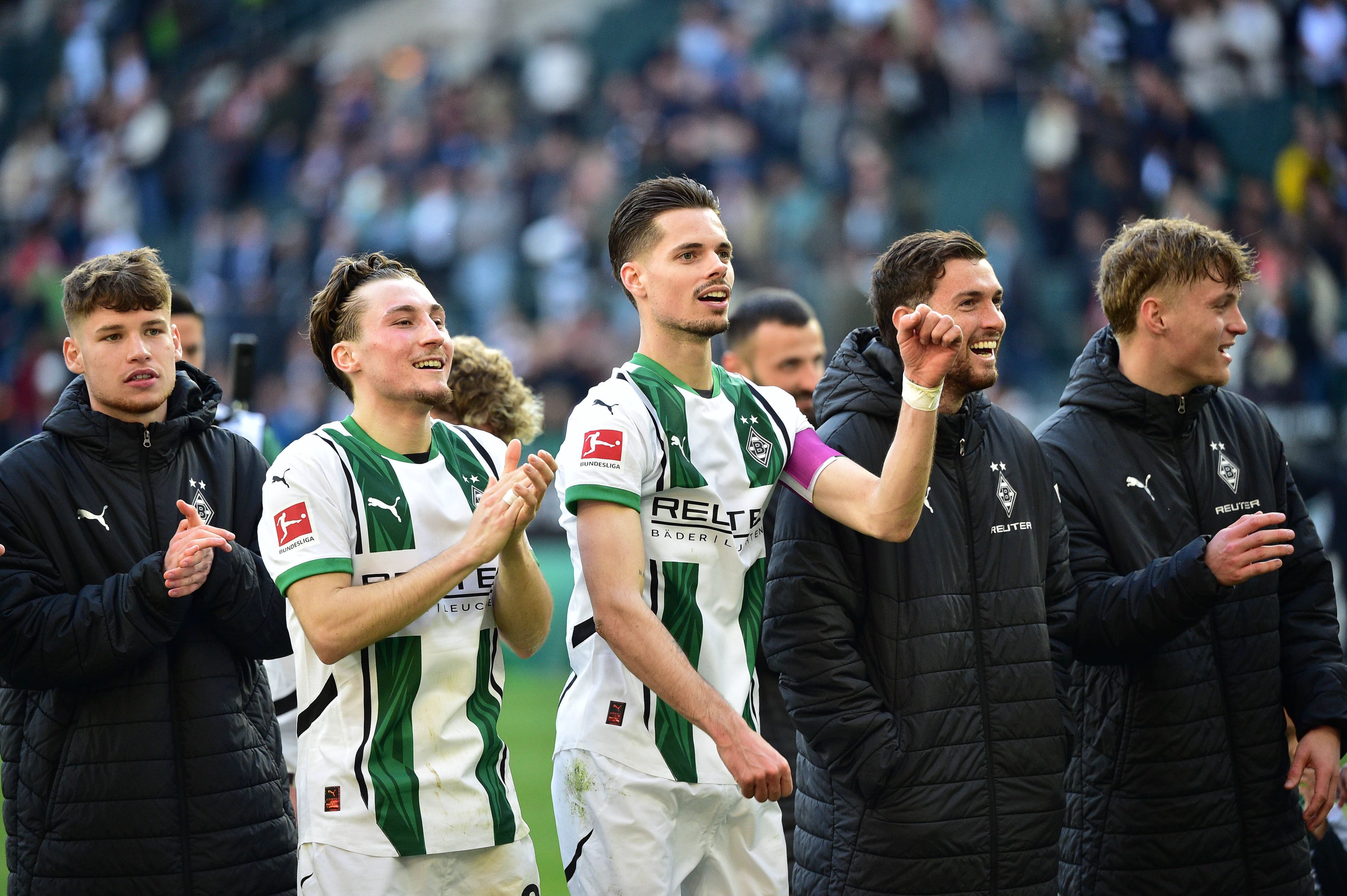 Spieler von Borussia Mönchengladbach feiern mit den Fans.