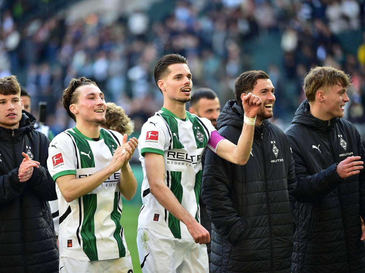 Spieler von Borussia Mönchengladbach feiern mit den Fans.