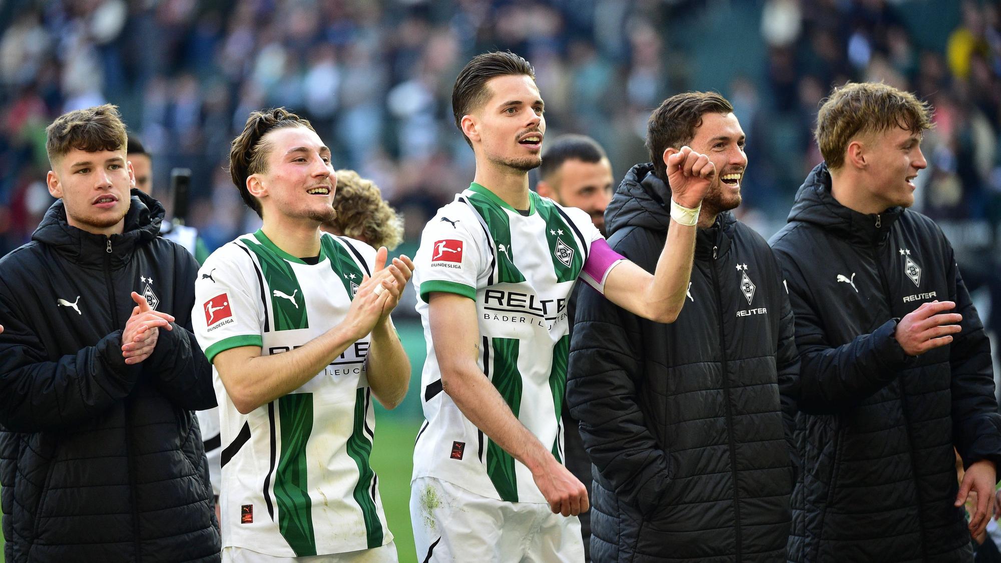 Spieler von Borussia Mönchengladbach feiern mit den Fans.