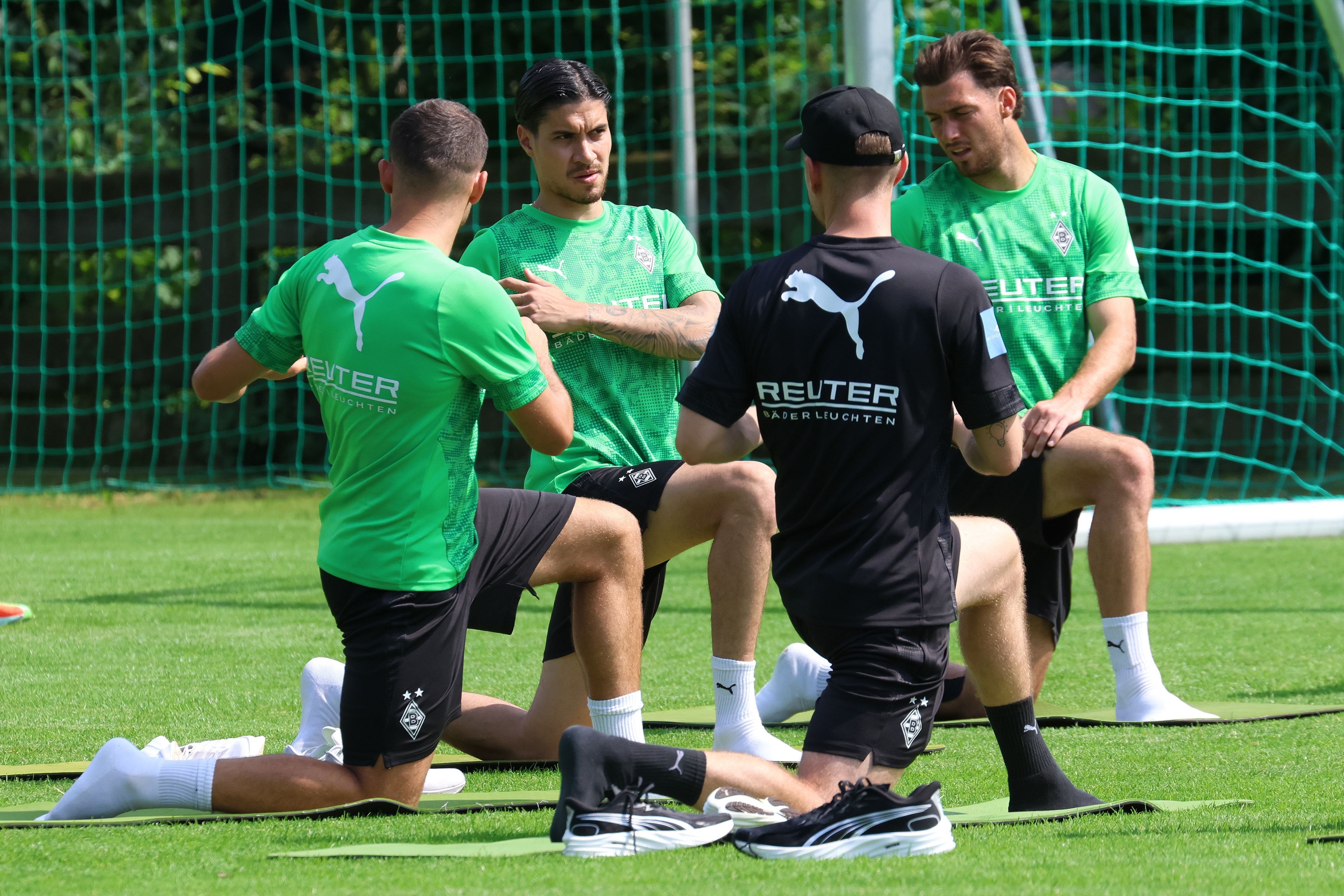Im Trainingslager von Borussia Mönchengladbach dehnen sich Kevin Stöger, Kevin Diks und Joe Scally.
