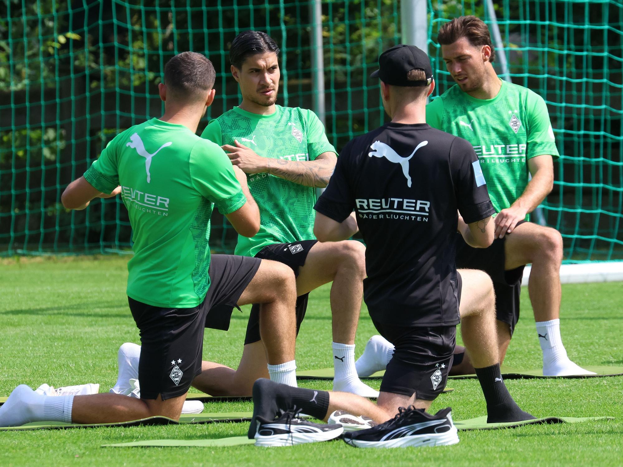 Im Trainingslager von Borussia Mönchengladbach dehnen sich Kevin Stöger, Kevin Diks und Joe Scally.