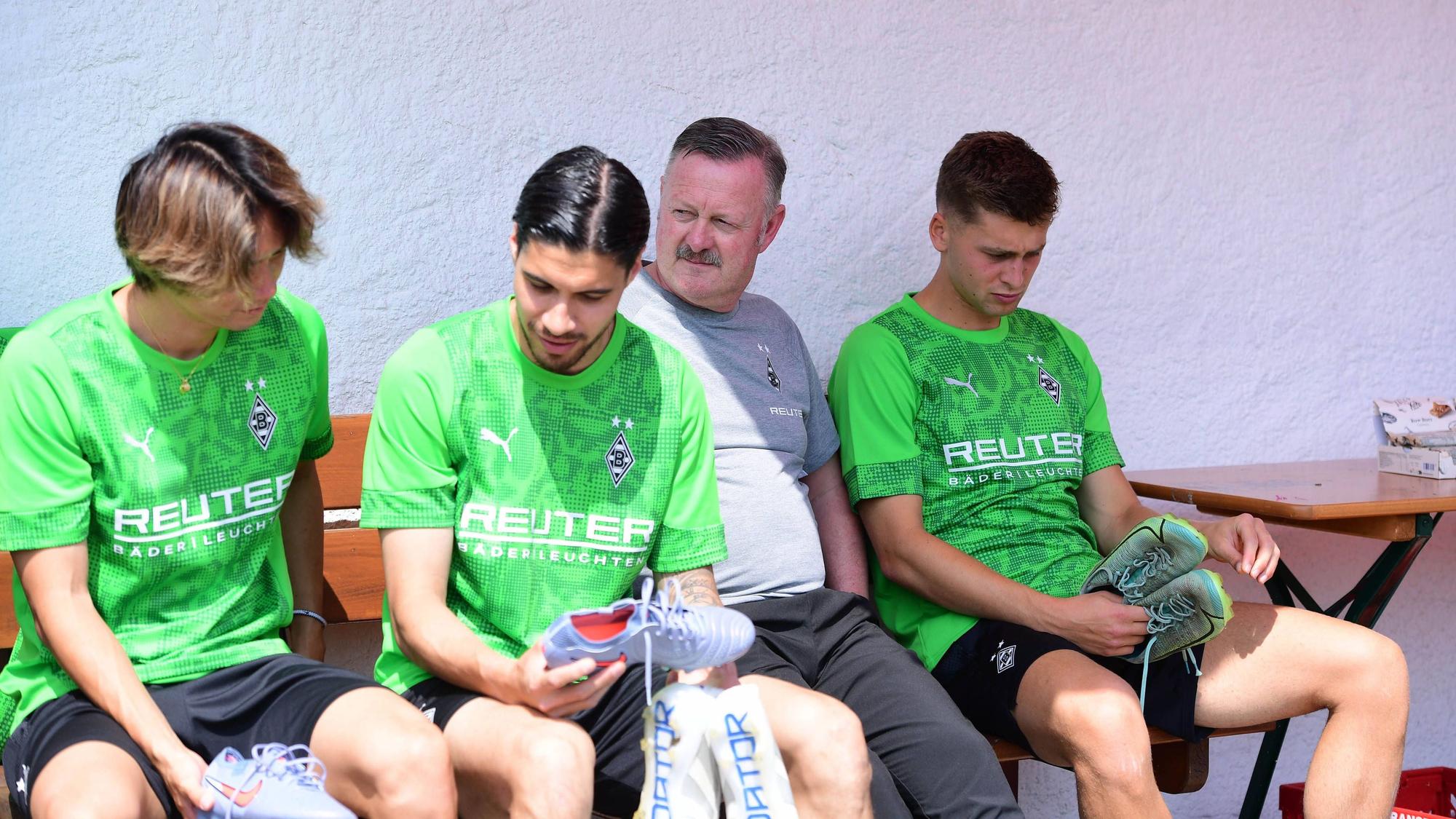 Ko Itakura (l.), Kevin Diks (2.v.l), Roland Virkus und Oscar Fraulo (r.) sitzen auf einer Bank.