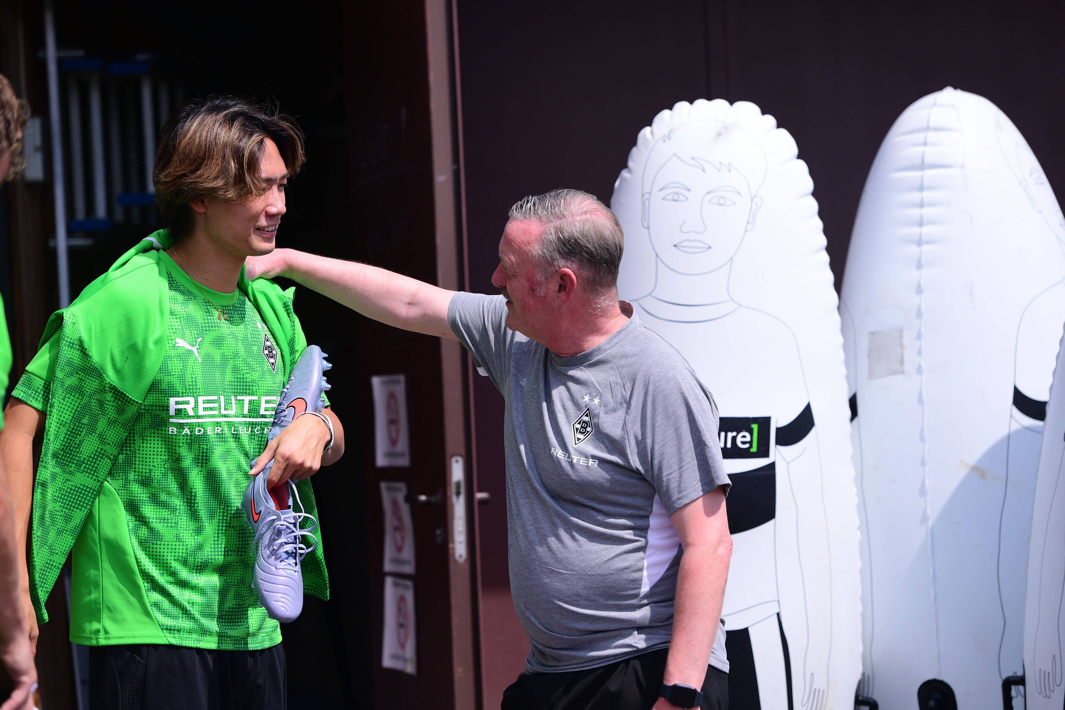Ko Itakura plaudert angeregt mit Gladbachs Sportboss Roland Virkus im Trainingslager am 19. Juli 2025.