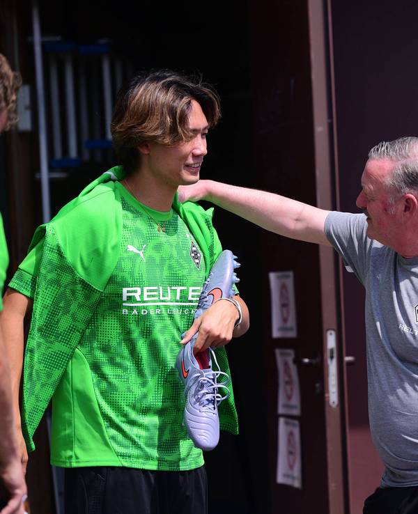 Ko Itakura plaudert angeregt mit Gladbachs Sportboss Roland Virkus im Trainingslager am 19. Juli 2025.