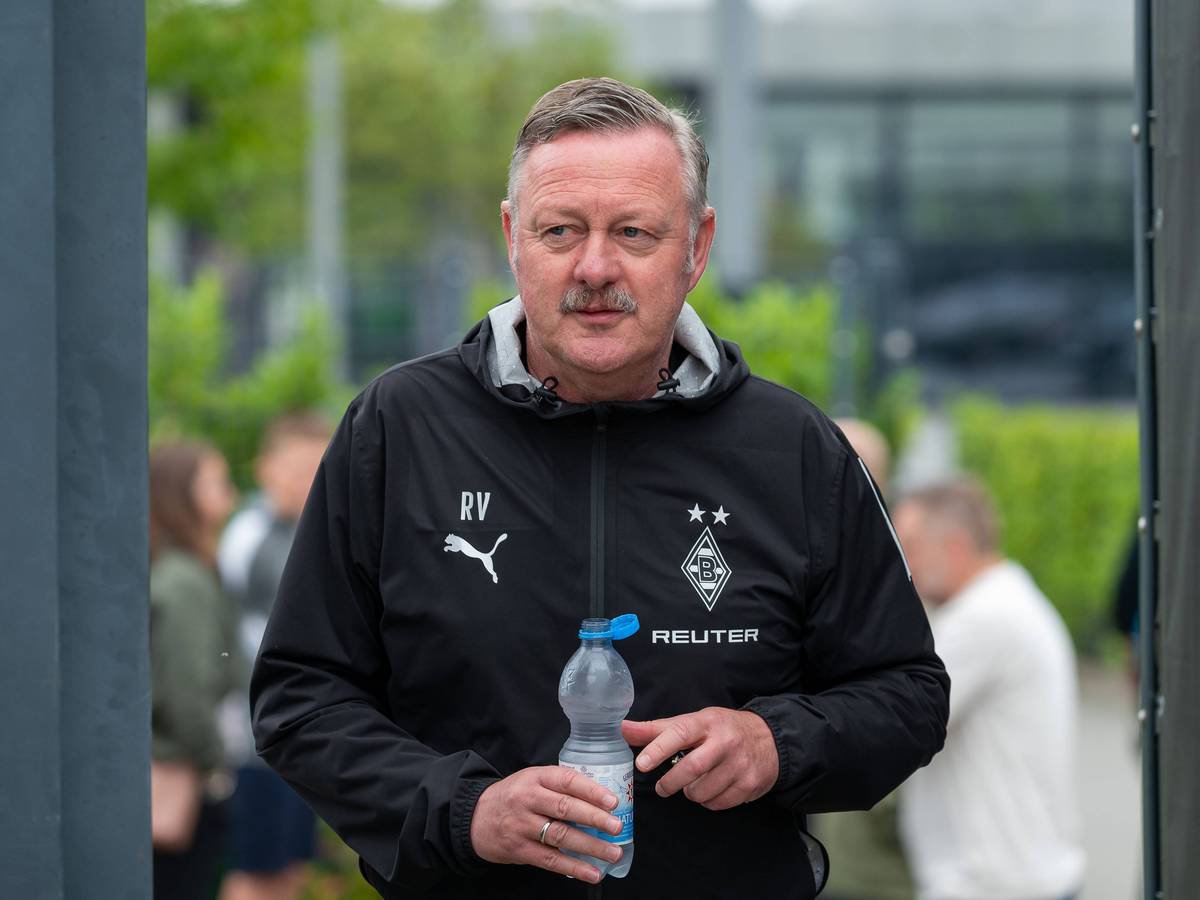 Roland Virkus betritt mit einer Wasserflasche den Trainingsplatz.