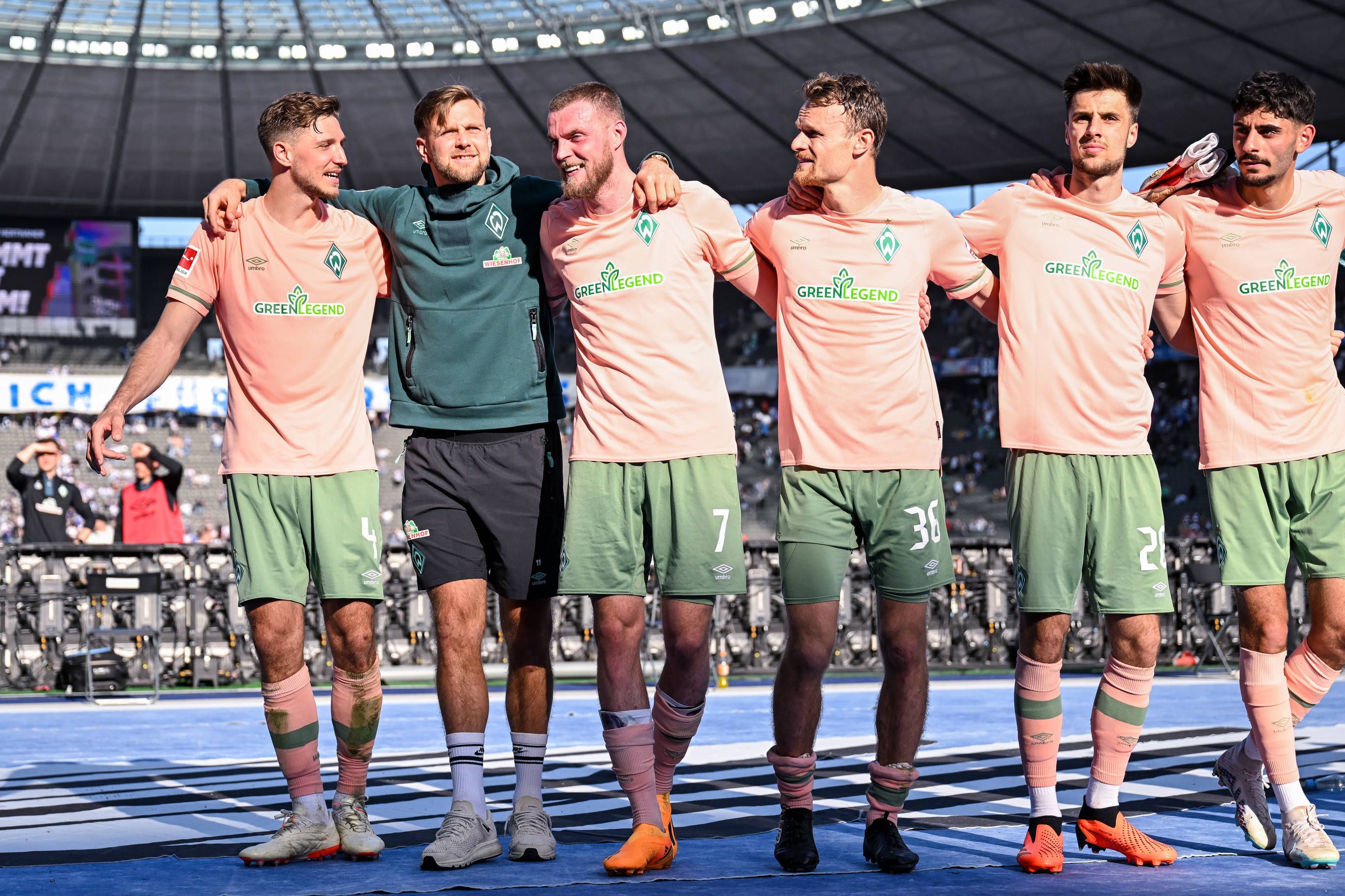 Spieler von Werder Bremen jubeln mit den Fans im Olypiastadion.