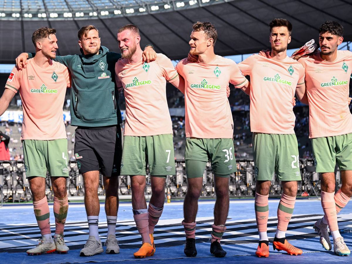 Spieler von Werder Bremen jubeln mit den Fans im Olypiastadion.