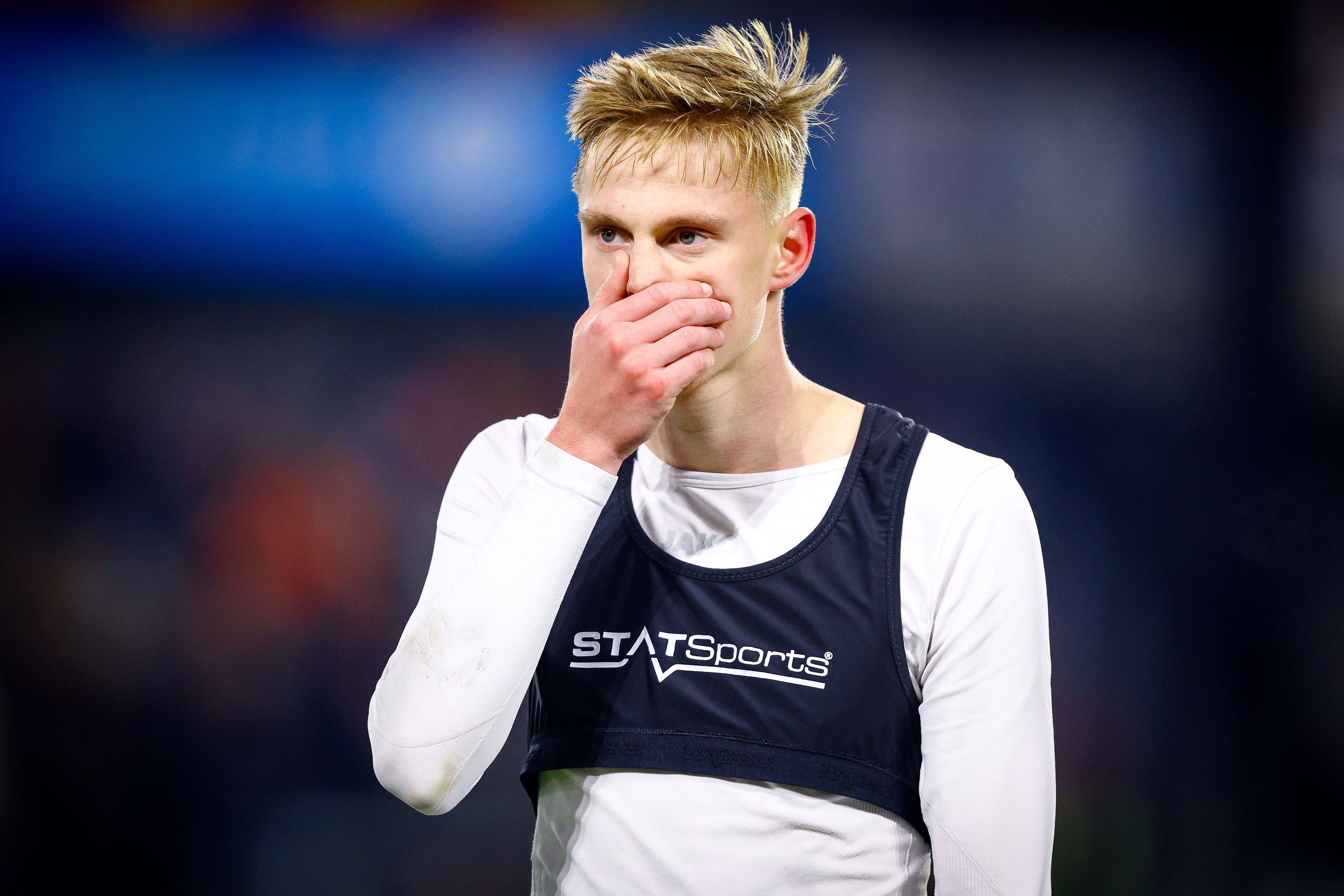 Zeno van den Bosch hält sich die Hand vor den Mund.