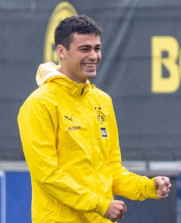 Giovanni Reyna lacht in einer gelben Regenjacke.