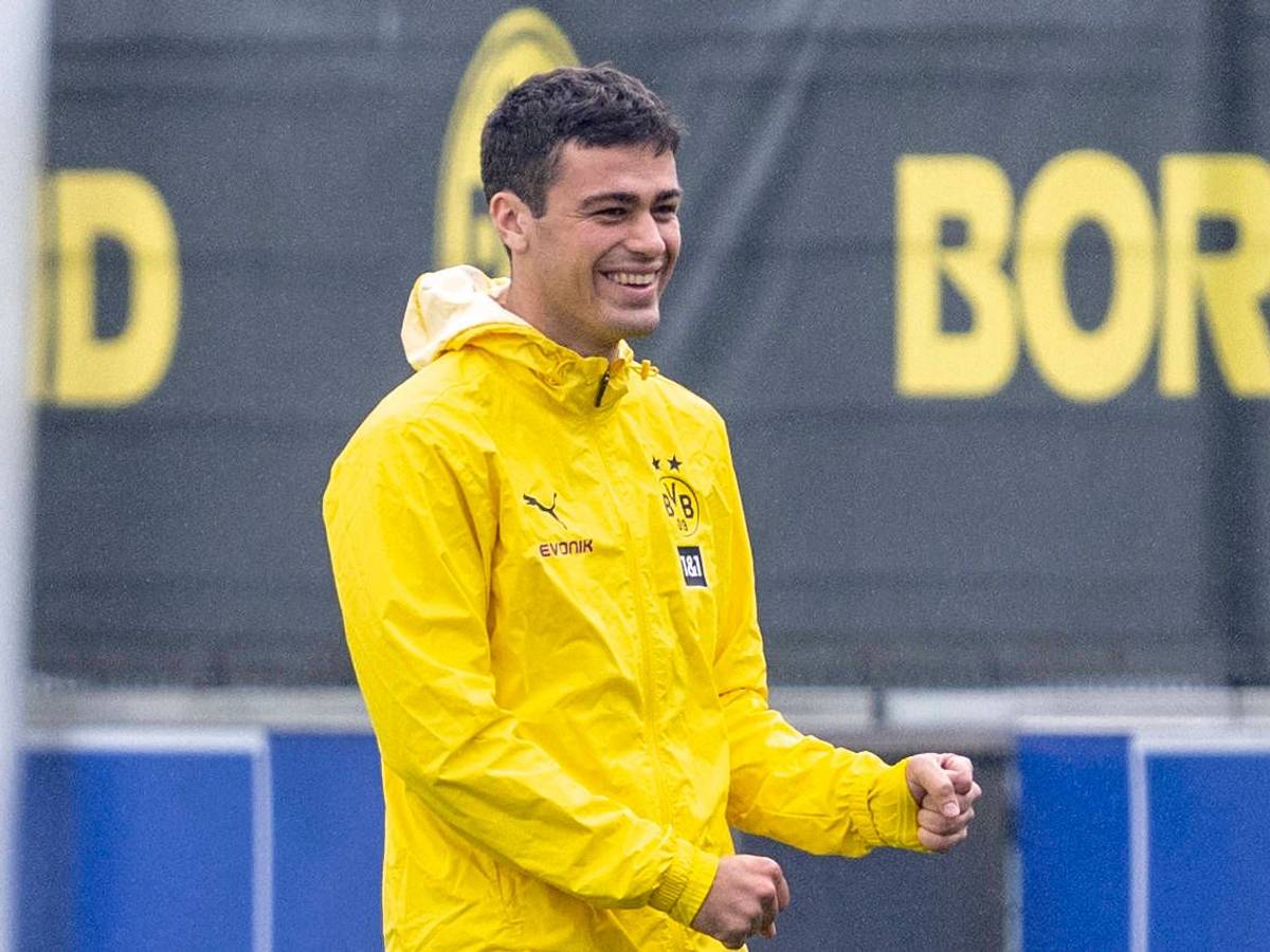 Giovanni Reyna lacht in einer gelben Regenjacke.