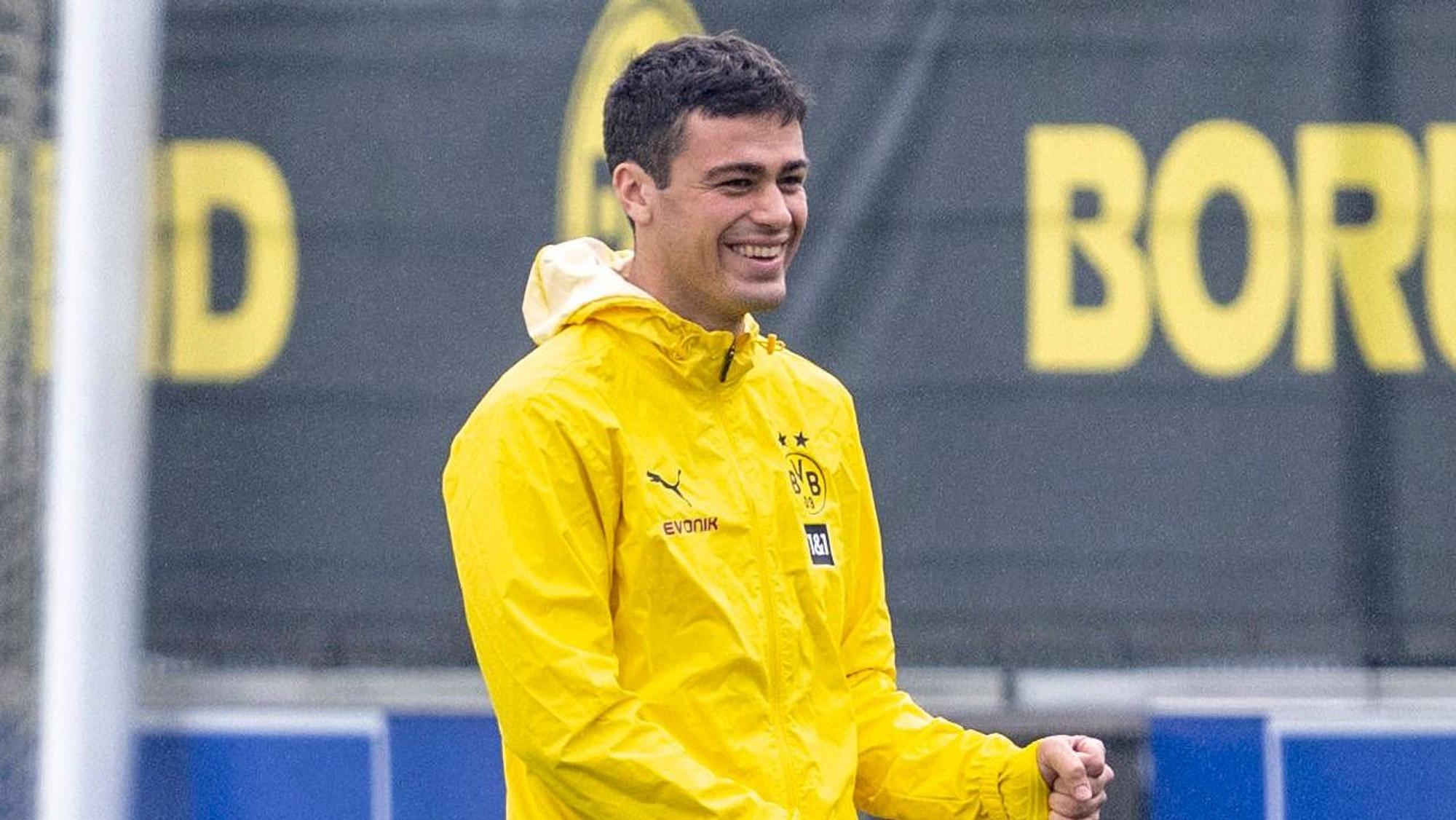Giovanni Reyna lacht in einer gelben Regenjacke.
