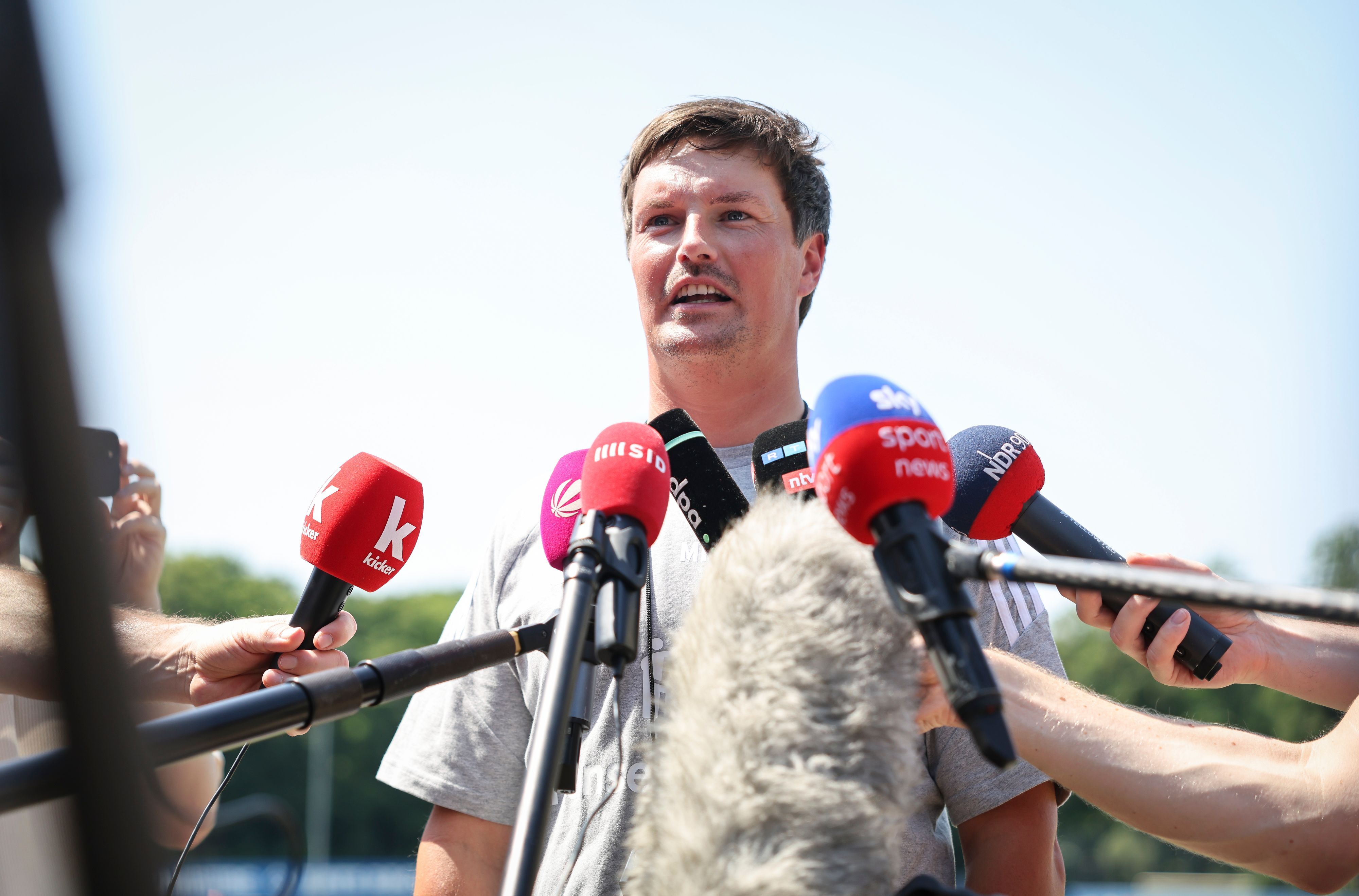HSV-Trainer Merlin Polzin spricht vor Mikrofonen.
