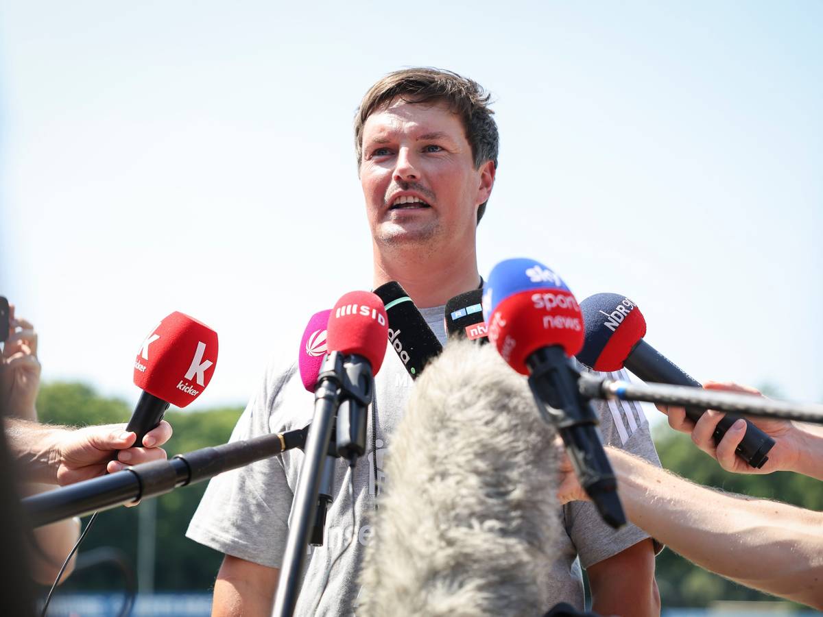 HSV-Trainer Merlin Polzin spricht vor Mikrofonen.