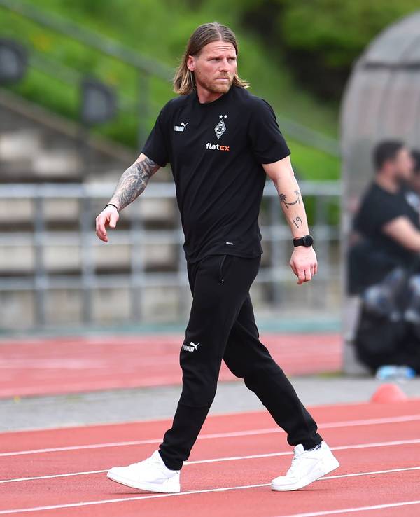 Eugen Polanski geht über die Tartanbahn neben dem Spielfeld.