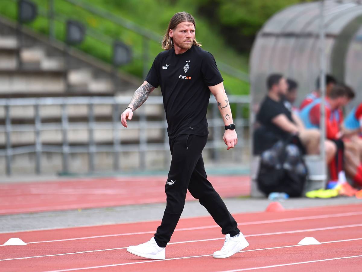 Eugen Polanski geht über die Tartanbahn neben dem Spielfeld.