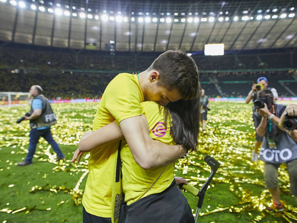 Julian Weigl umarmt Sarah Richmond.