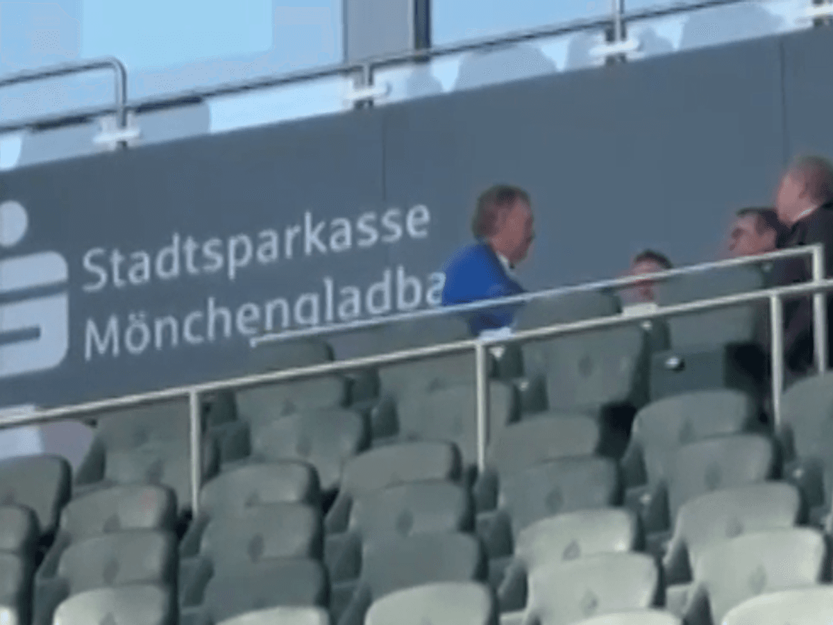Peter Neururer und mehrere andere Personen sitzen auf der Tribüne im Borussia-Park.