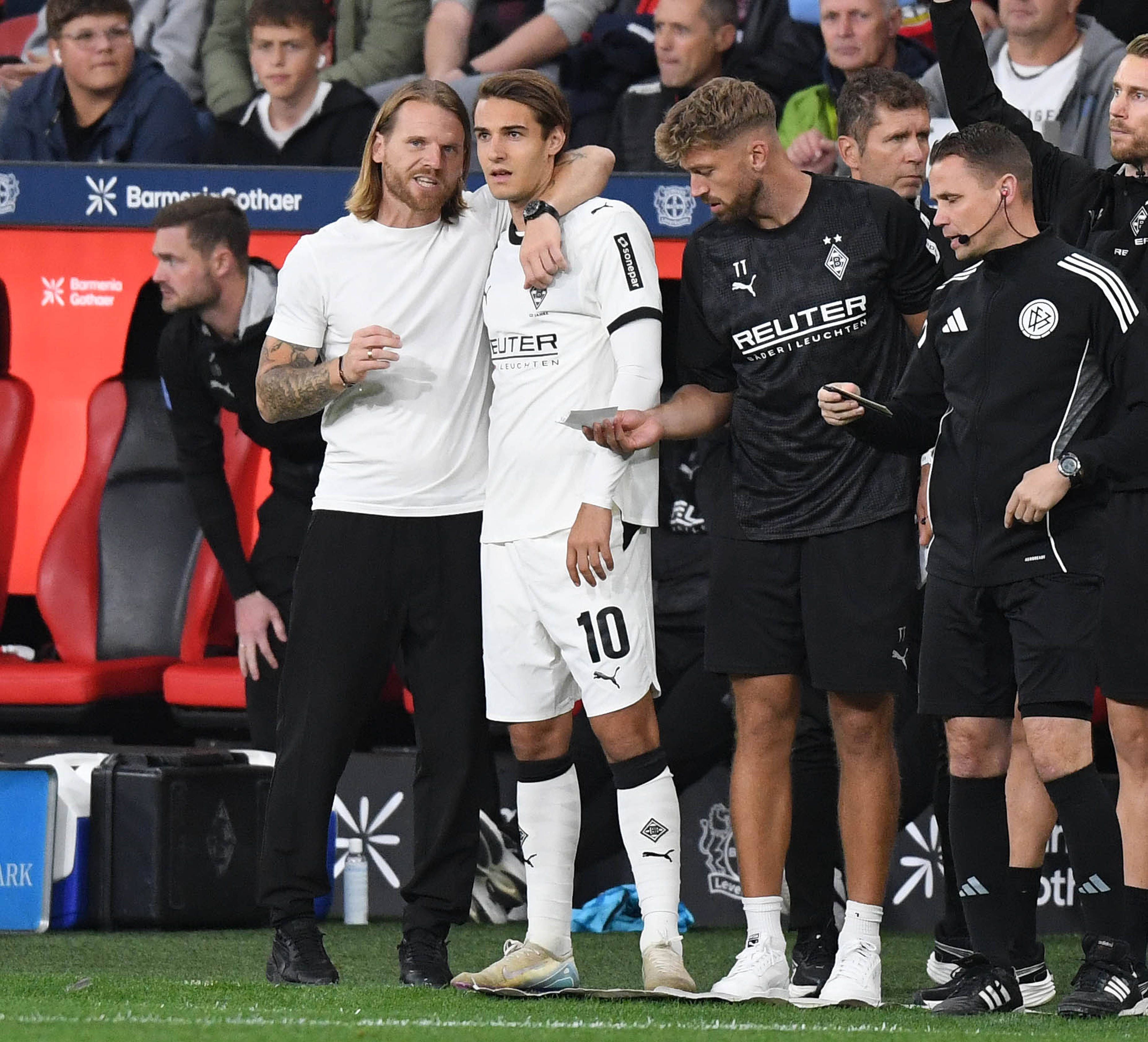 Gladbach-Trainer Eugen Polanski nimmt Florian Neuhaus in den Arm und gibt ihm Anweisungen vor der Einwechslung.
