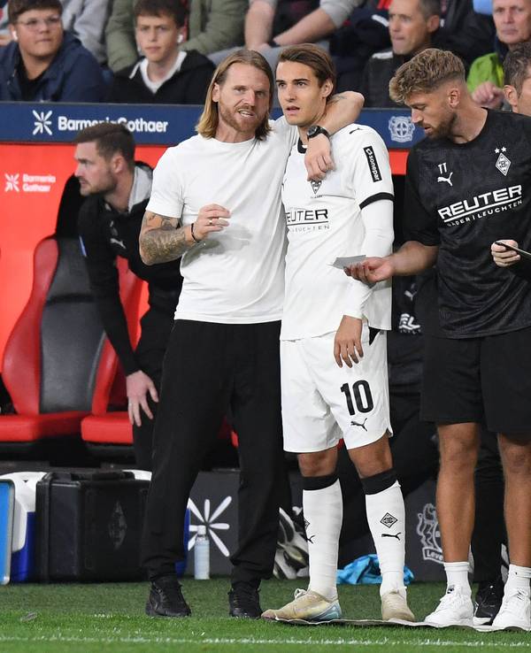 Gladbach-Trainer Eugen Polanski nimmt Florian Neuhaus in den Arm und gibt ihm Anweisungen vor der Einwechslung.