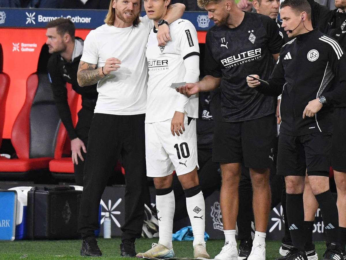 Gladbach-Trainer Eugen Polanski nimmt Florian Neuhaus in den Arm und gibt ihm Anweisungen vor der Einwechslung.