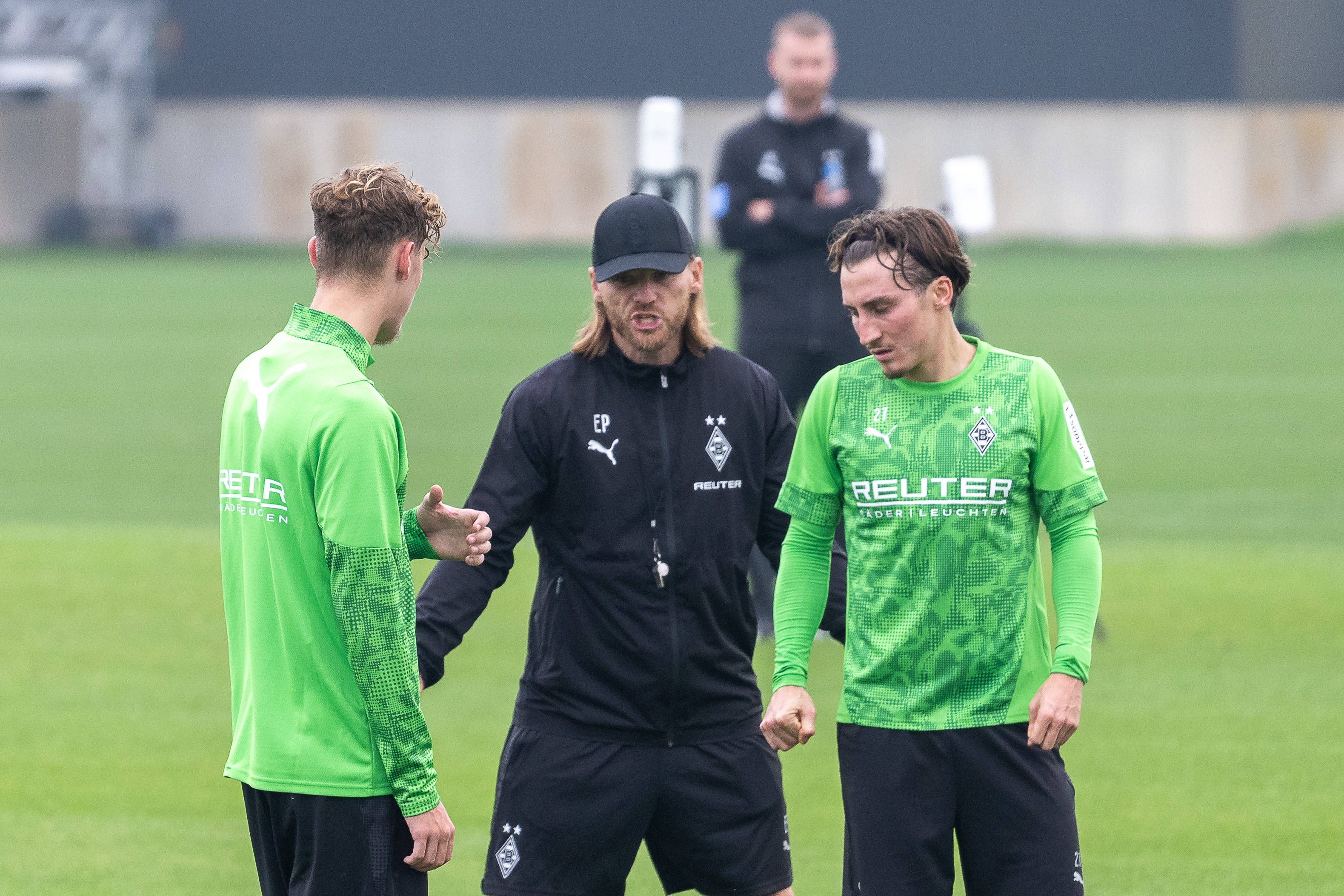 Eugen Polanski erklärt Niklas Swider und Rocco Reitz etwas im Training.