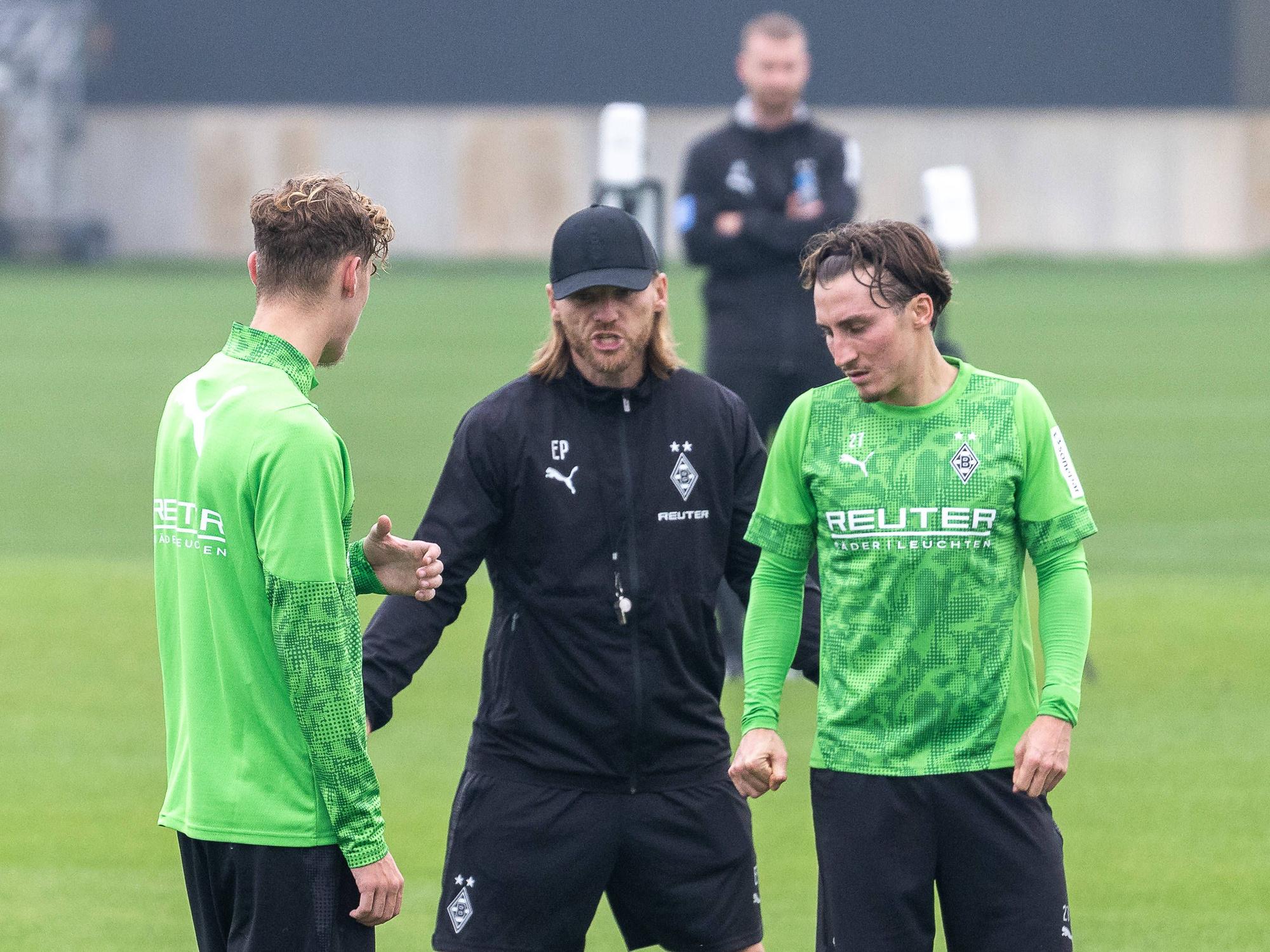 Eugen Polanski erklärt Niklas Swider und Rocco Reitz etwas im Training.