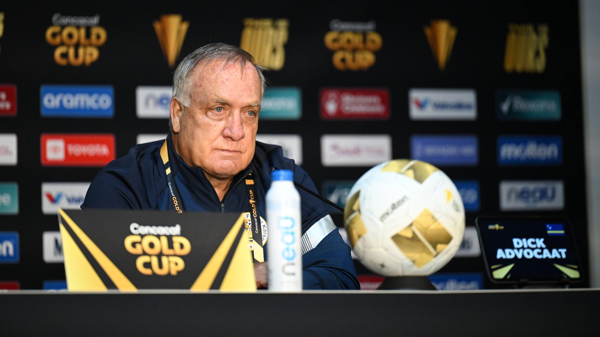 Dick Advocaat sitzt bei einer Pressekonferenz vor eine Mikrofon.