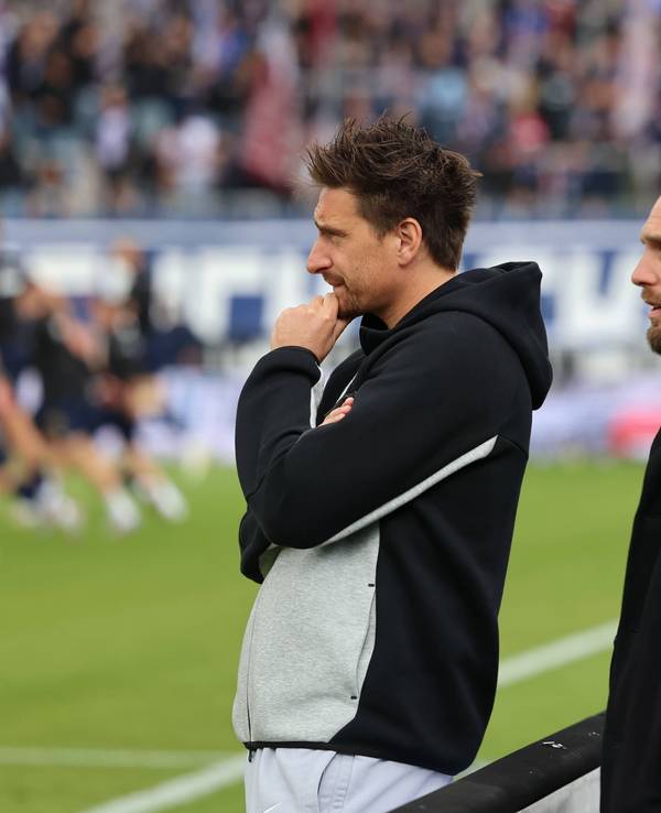 Vincent Wagner und Sportboss Niks-Ole Book beobachten das Aufwärmen.